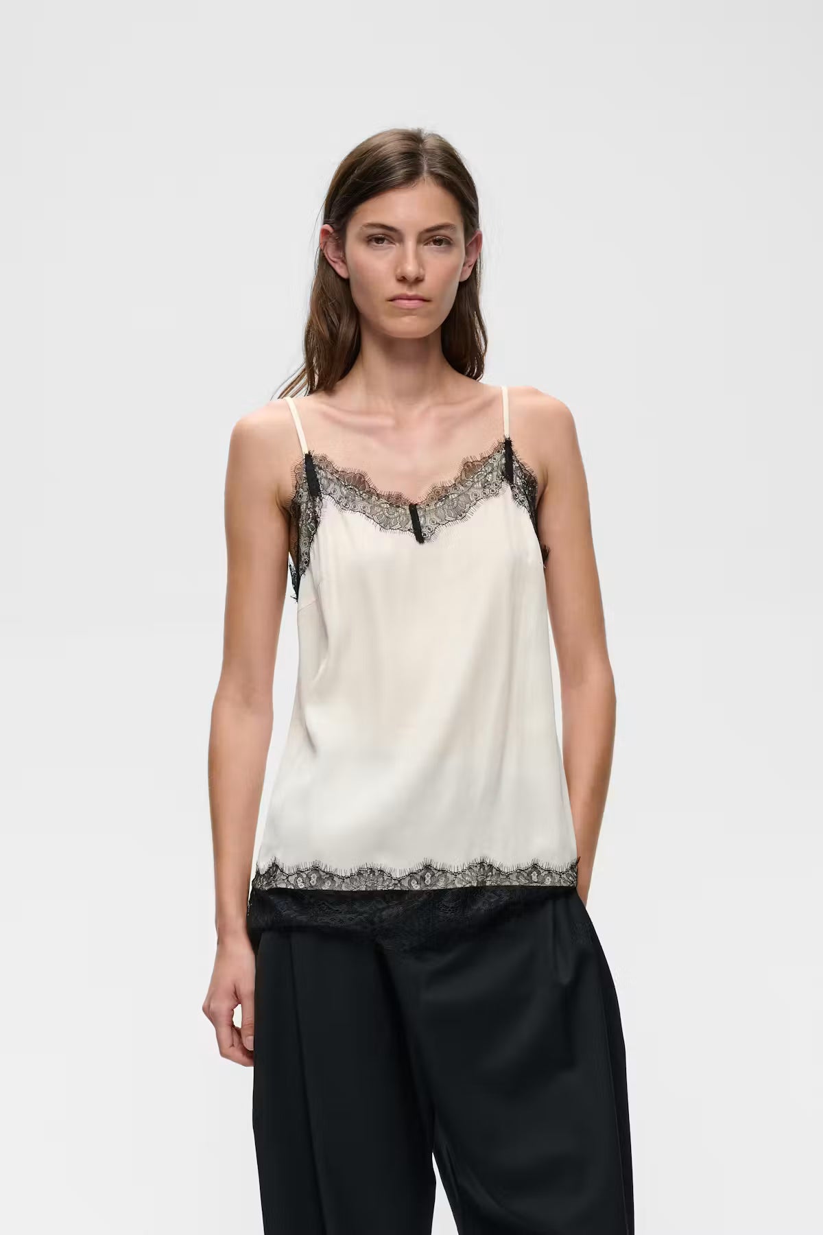Ivory satin camisole with black lace trim at neckline and hem, thin straps