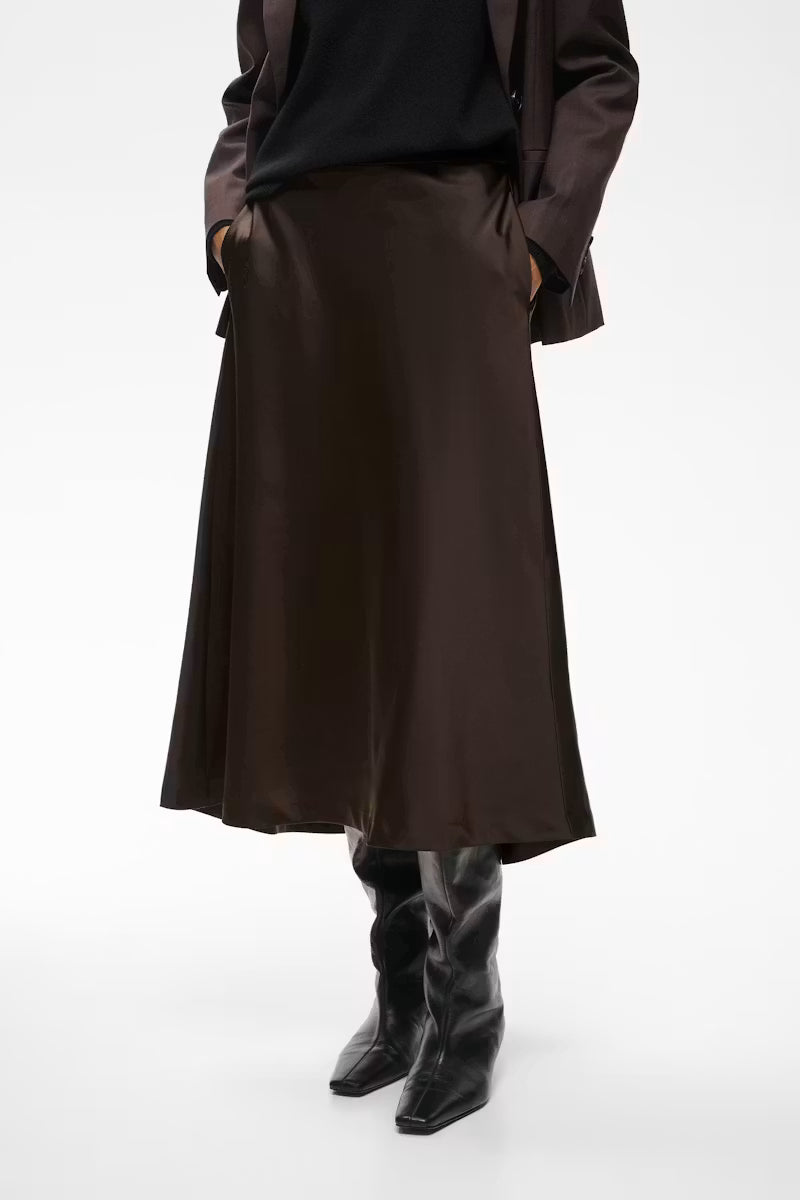 Chocolate brown satin midi skirt with A-line silhouette, styled with black boots