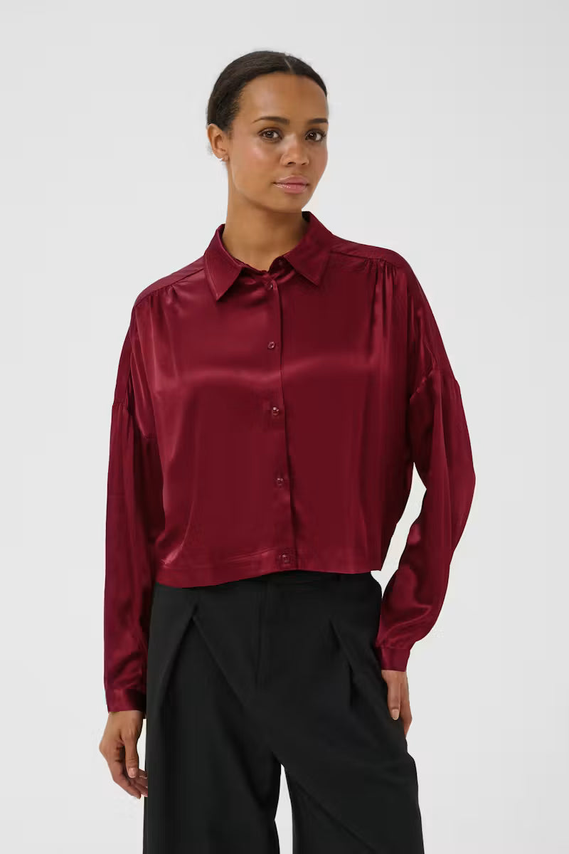 Burgundy satin cropped button-up shirt with long sleeves and classic collar