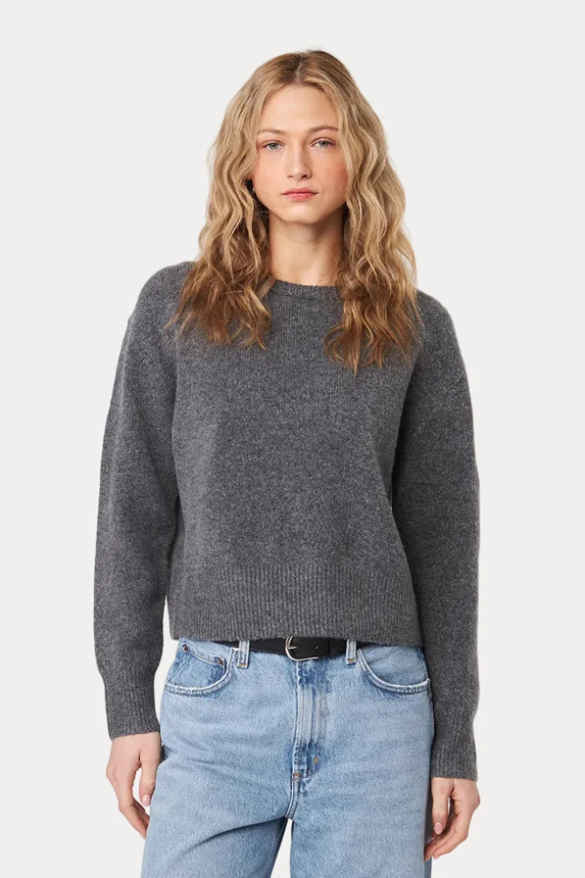 Woman wearing a granite grey cropped crew neck knit sweater with light blue jeans