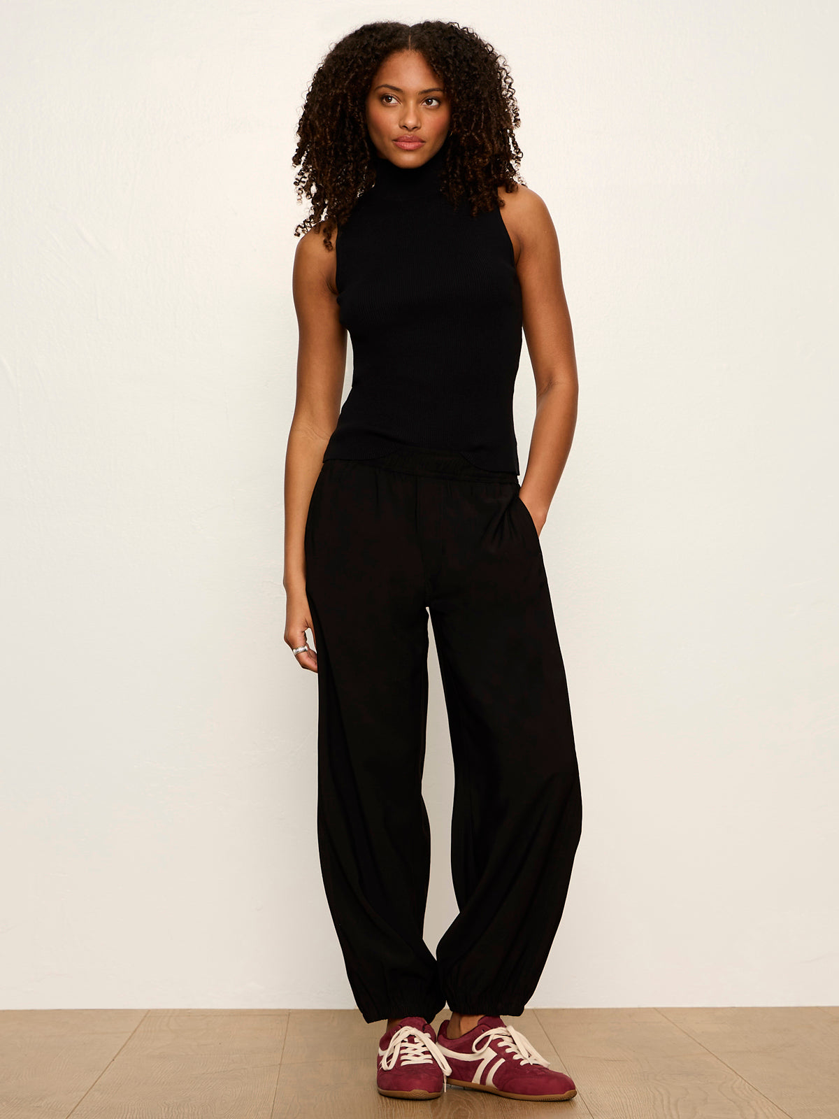 Model wearing Sanctuary Micro Balloon Pant in black with sleeveless turtleneck top