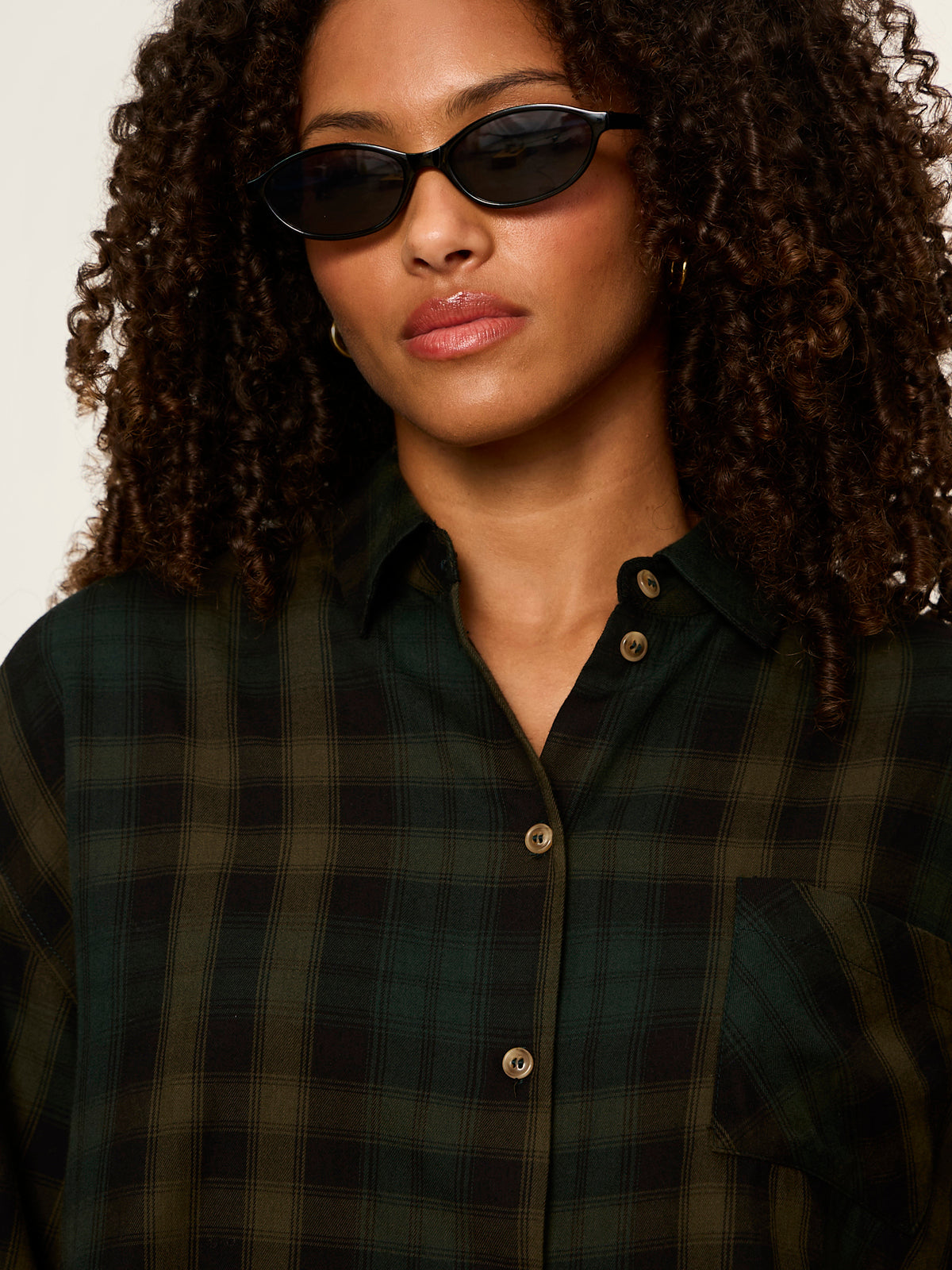 Model wearing Sanctuary Autumn Edit Flannel shirt in forest plaid green and black check pattern