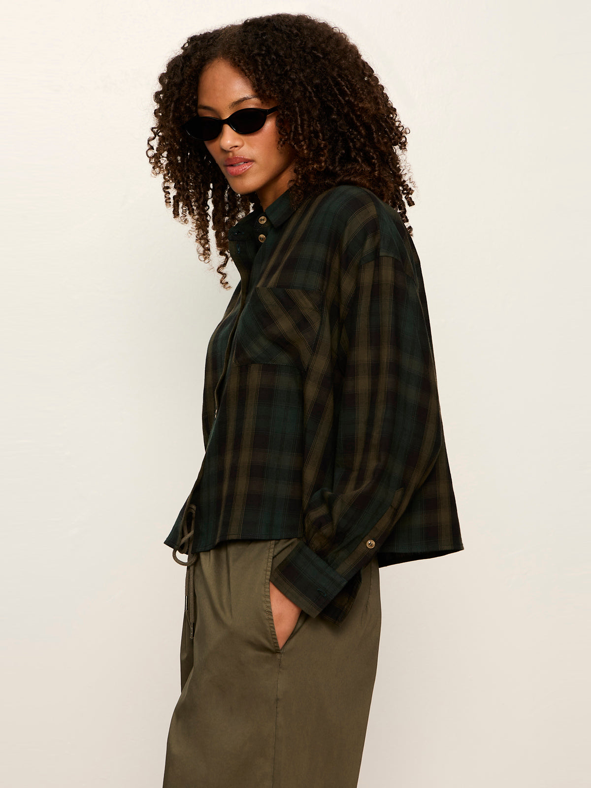 Model wearing Sanctuary Autumn Edit Flannel in forest plaid cropped button-up shirt, side view