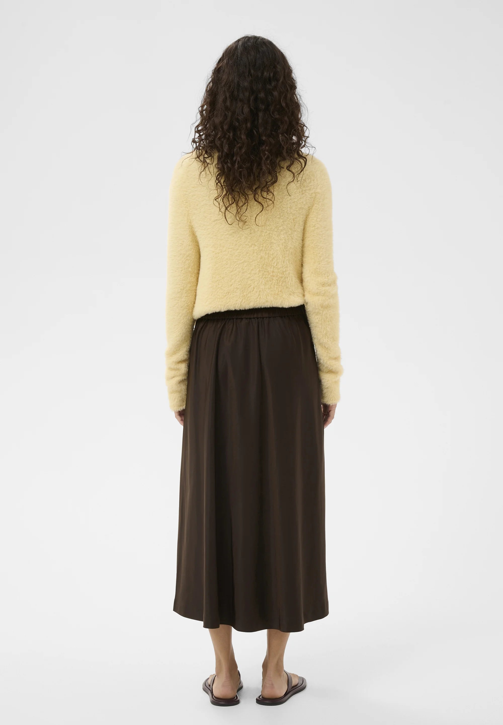 Chocolate brown midi skirt with elastic waist, shown from the back on a model