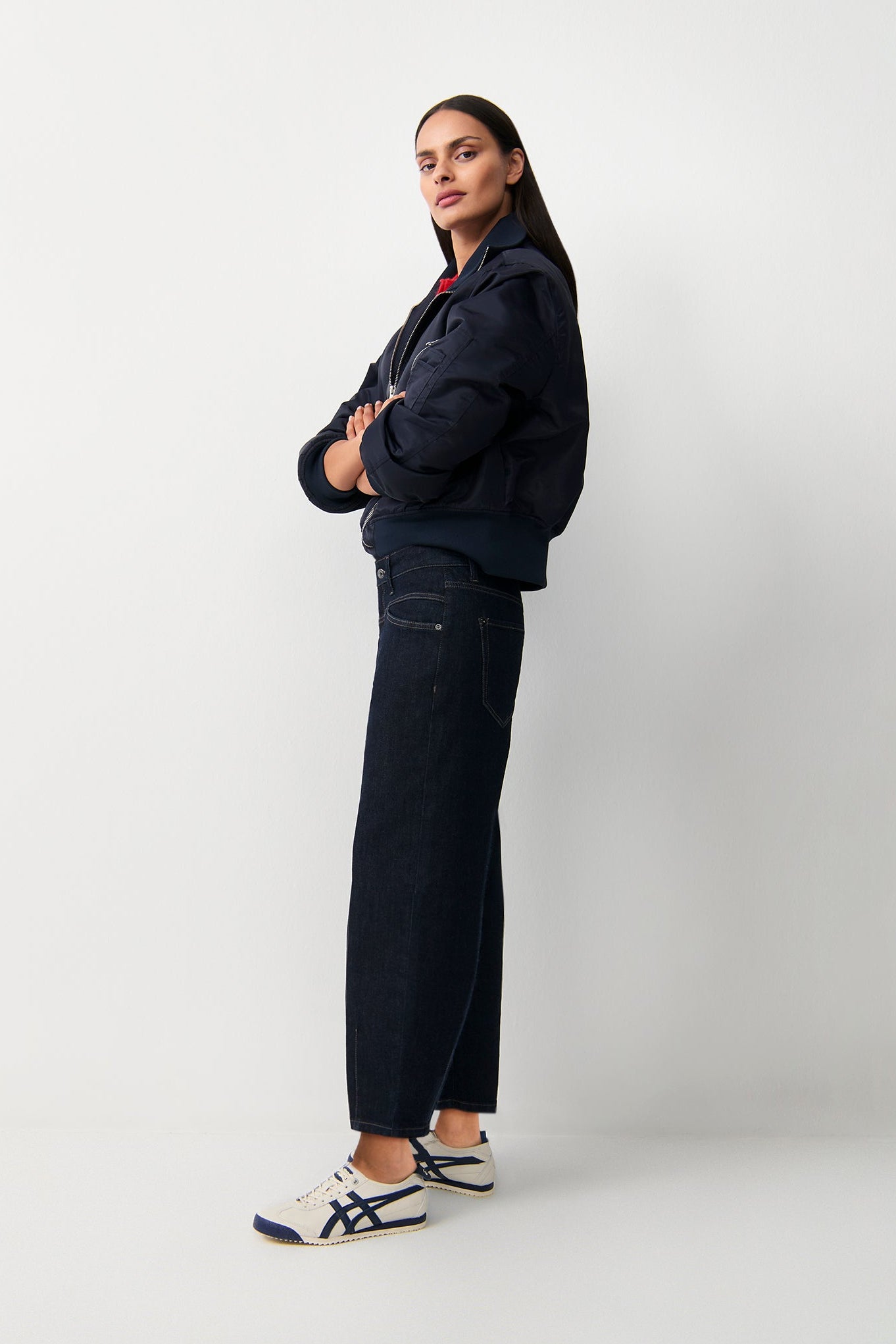 Model wearing Cambio Elin Modern Rinsed wide-leg dark indigo jeans with navy jacket, side view.