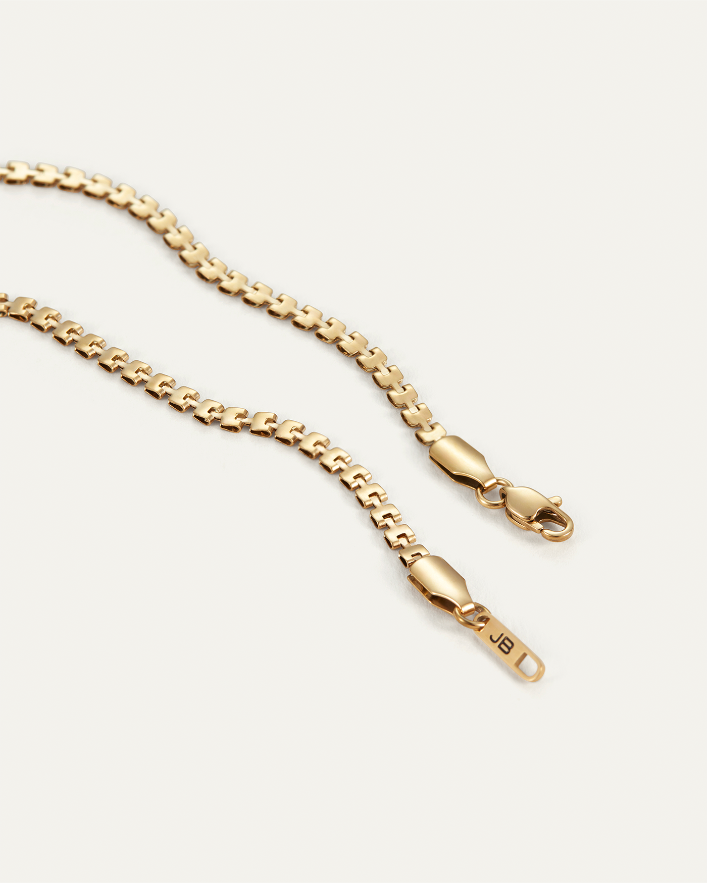 Close-up detail of Jenny Bird Double Amalfi gold chain necklace showing clasp and JB tag