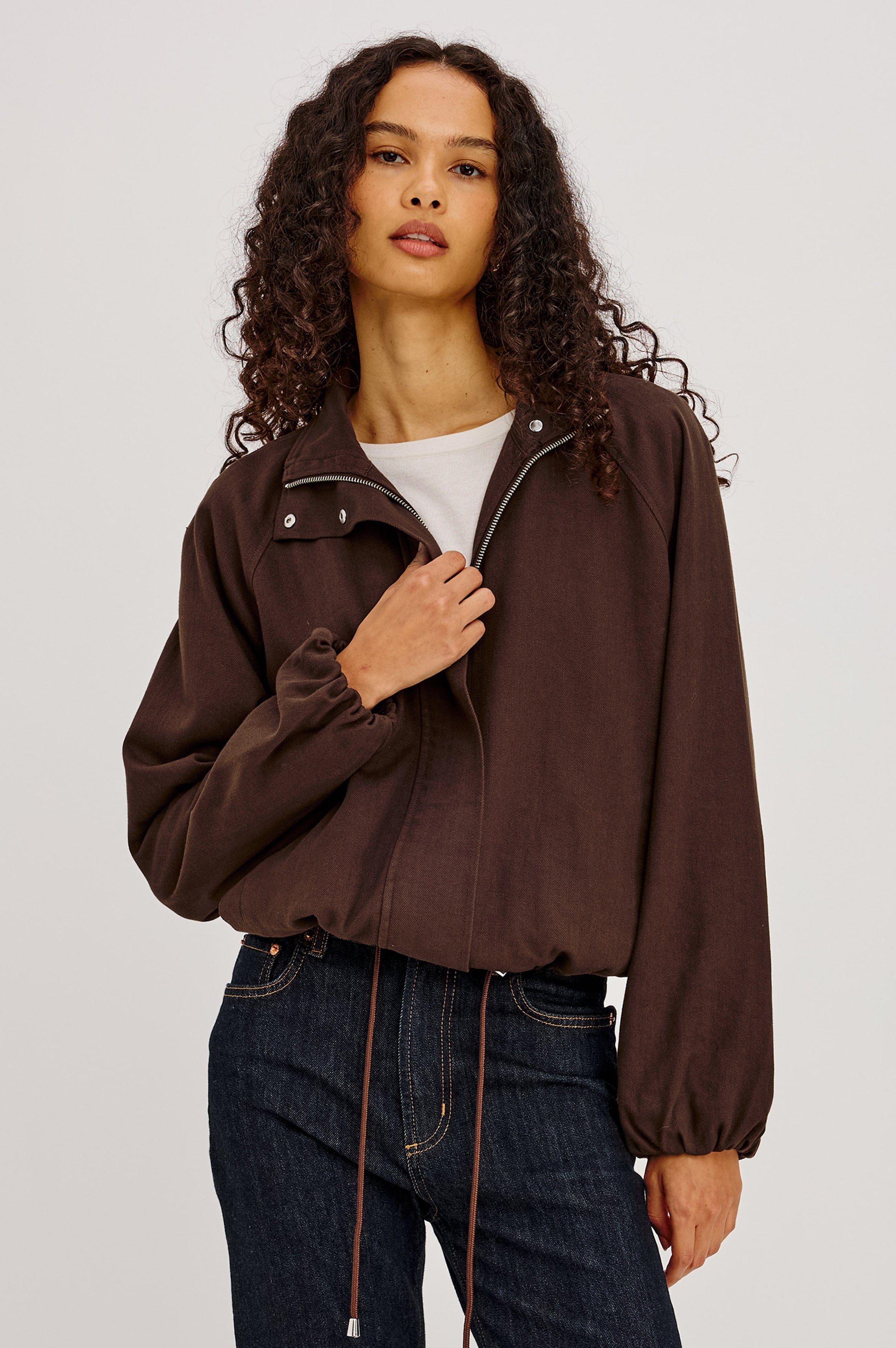 Model wearing Rails Blake cropped zip-up jacket in espresso brown with balloon sleeves and drawstring hem