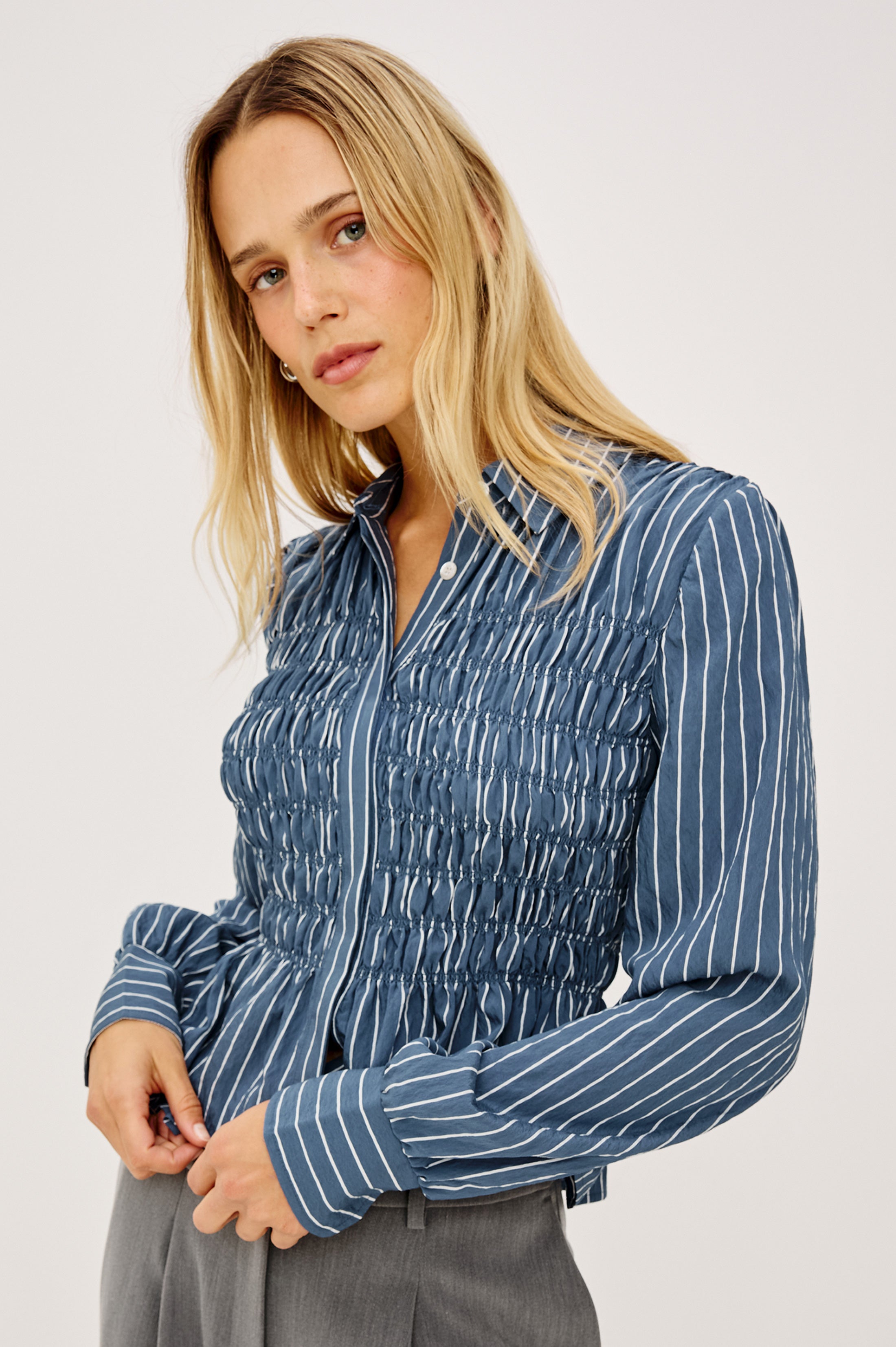 Model wearing Rails striped blue smocked button-down shirt with long sleeves and collar.