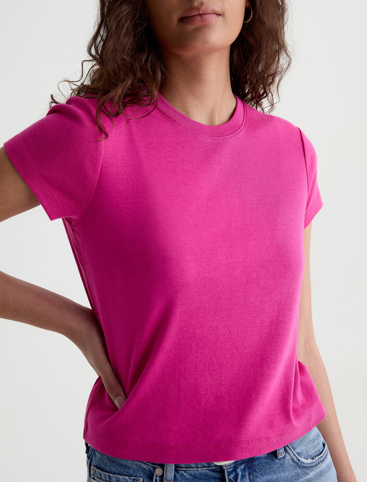 Model wearing AG Sadie Crew t-shirt in vibrant hot pink with short sleeves and crew neckline