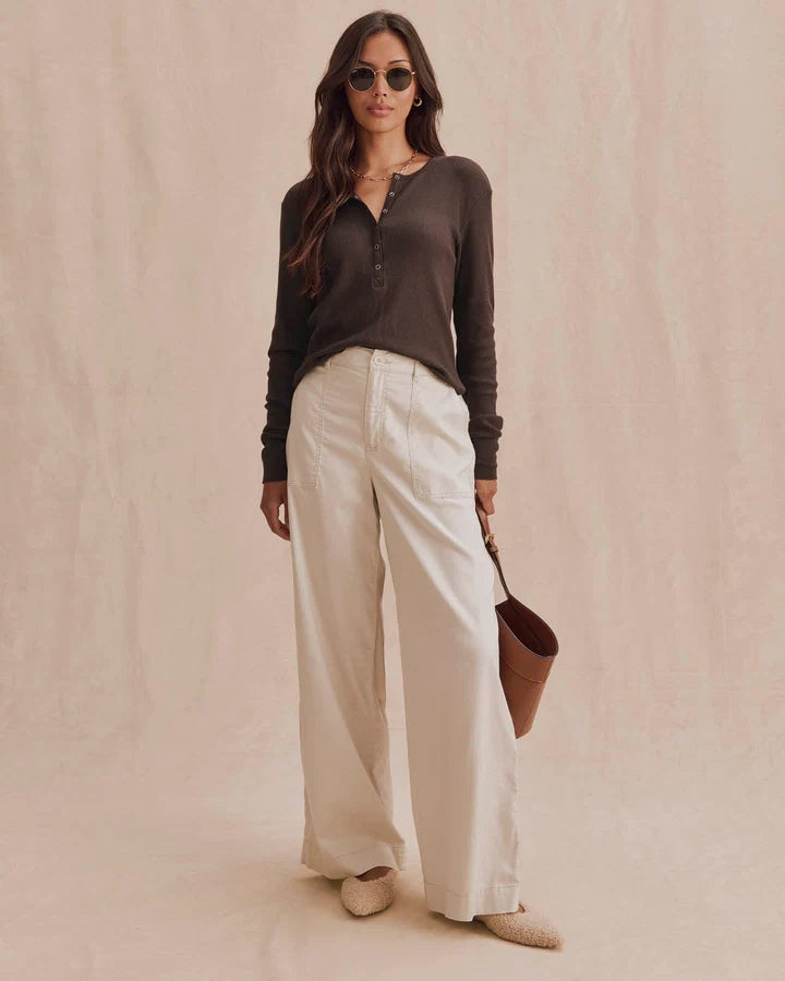Dark brown long-sleeve thermal henley top with button placket, worn with cream wide-leg pants