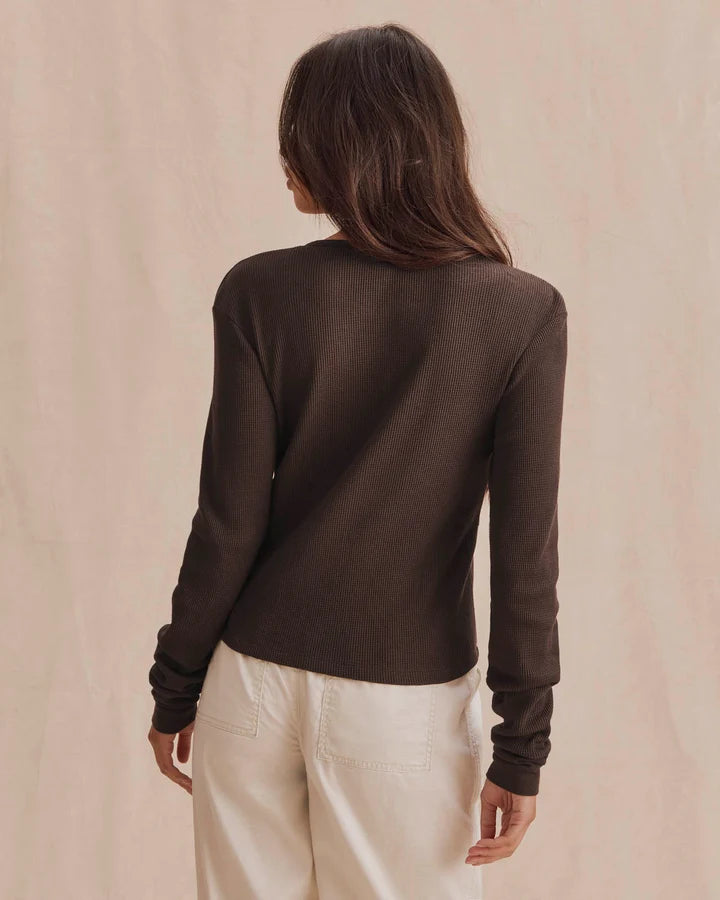 Dark brown waffle-knit long sleeve henley top, back view, paired with cream pants