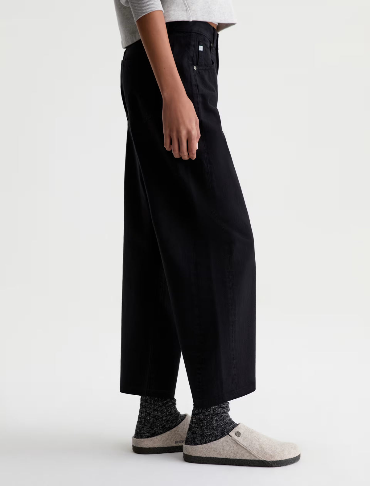 AG Hattie wide-leg black cropped jeans, high-rise, side view with slippers