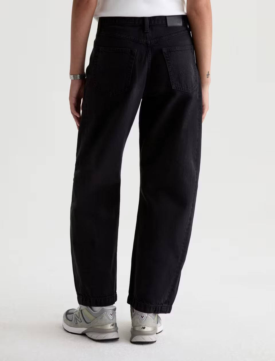 AG Hattie black wide-leg jeans back view, worn with white New Balance sneakers