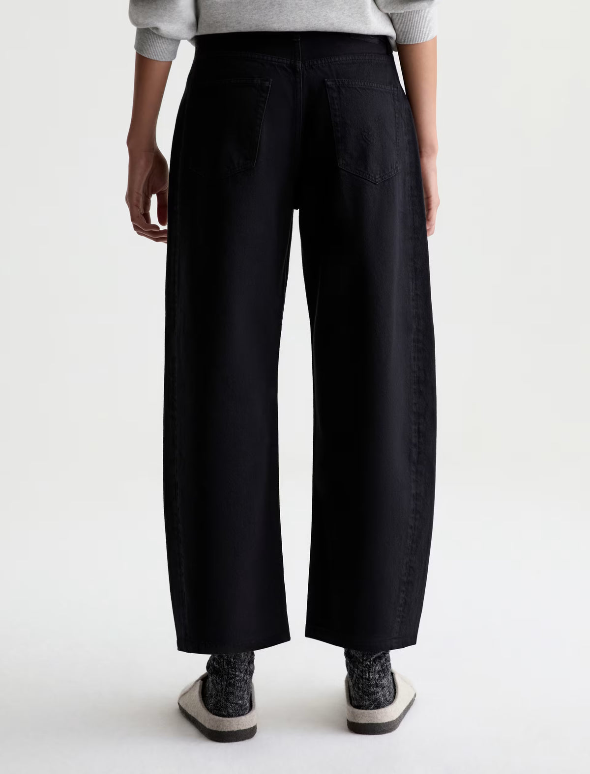 Back view of black wide-leg cropped denim jeans with patch pockets