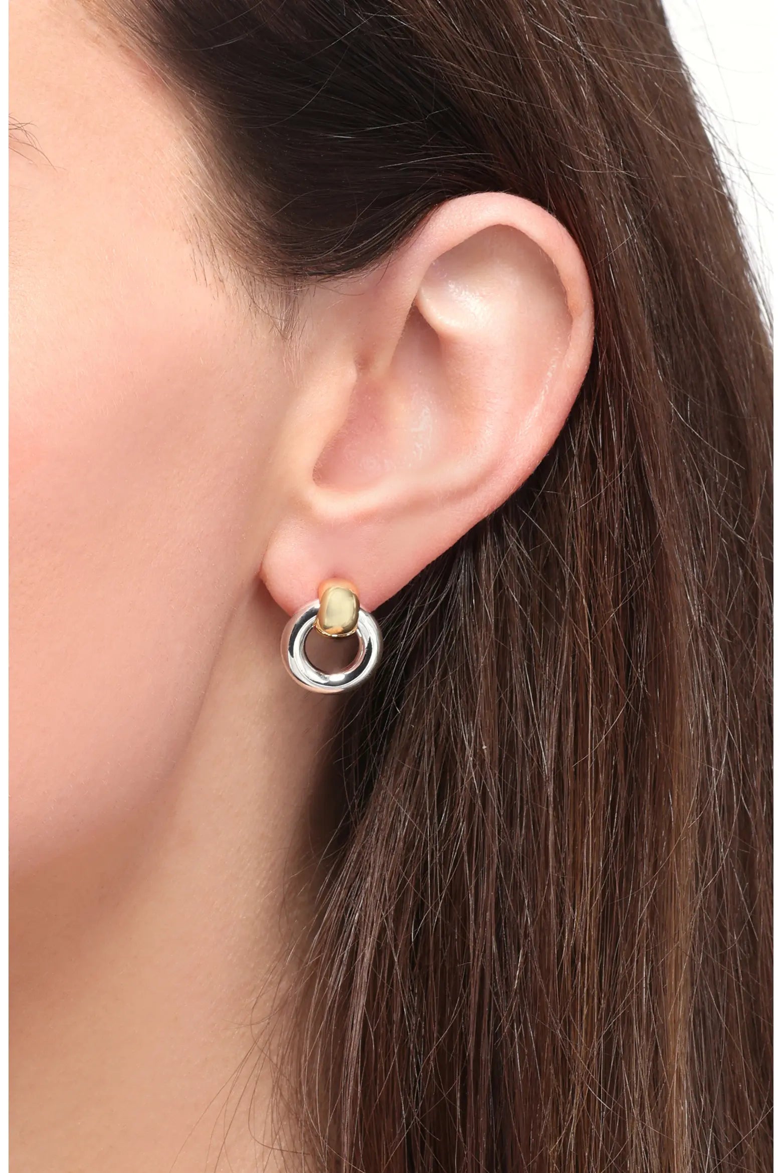 Close-up of a gold and silver two-tone hoop earring worn on the ear, featuring a rounded gold accent and polished finish.