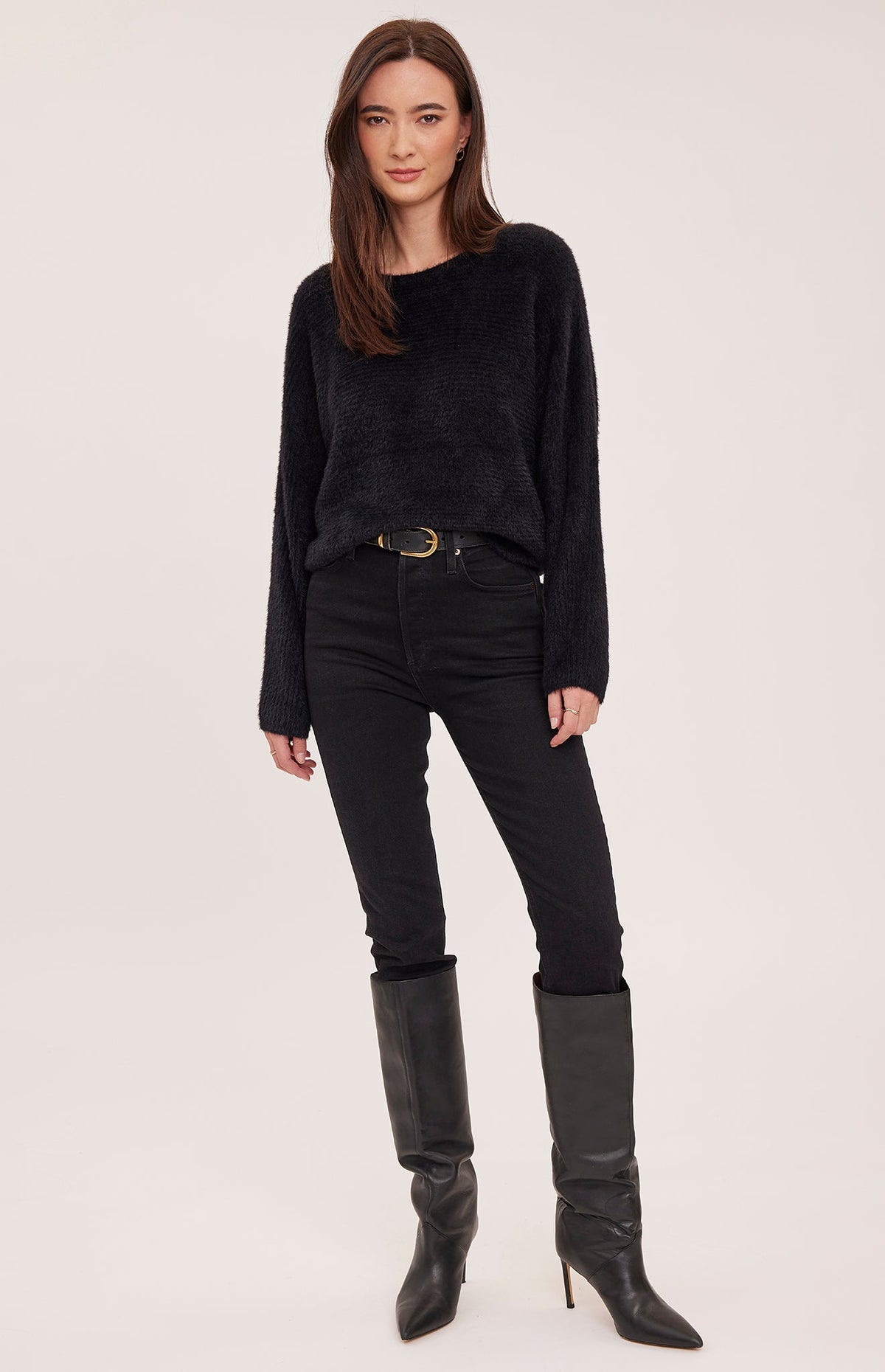 Model wearing Gentle Fawn Mara black fuzzy knit sweater with black jeans and boots