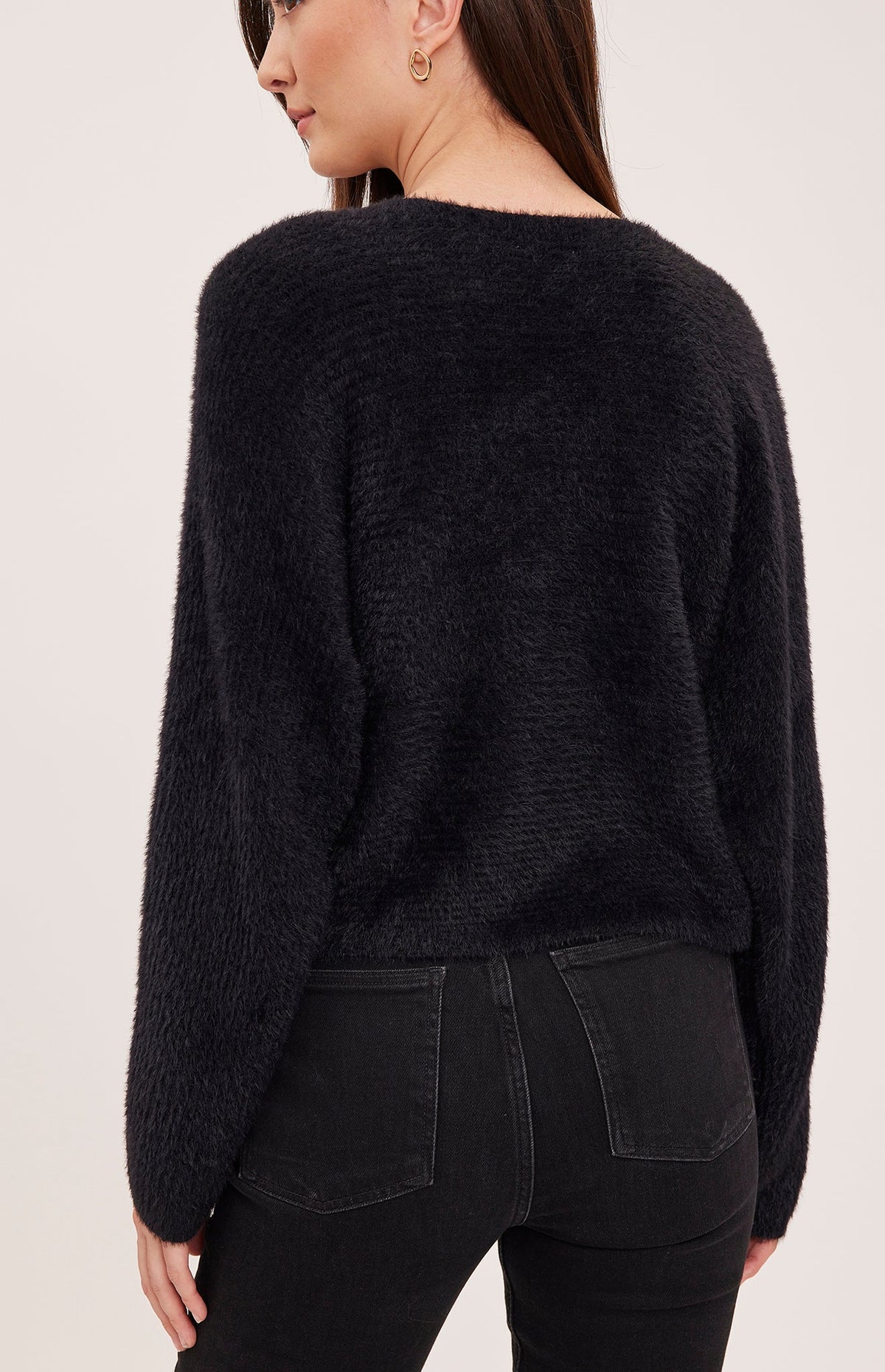 Back view of Gentle Fawn Mara black fuzzy knit sweater worn by female model