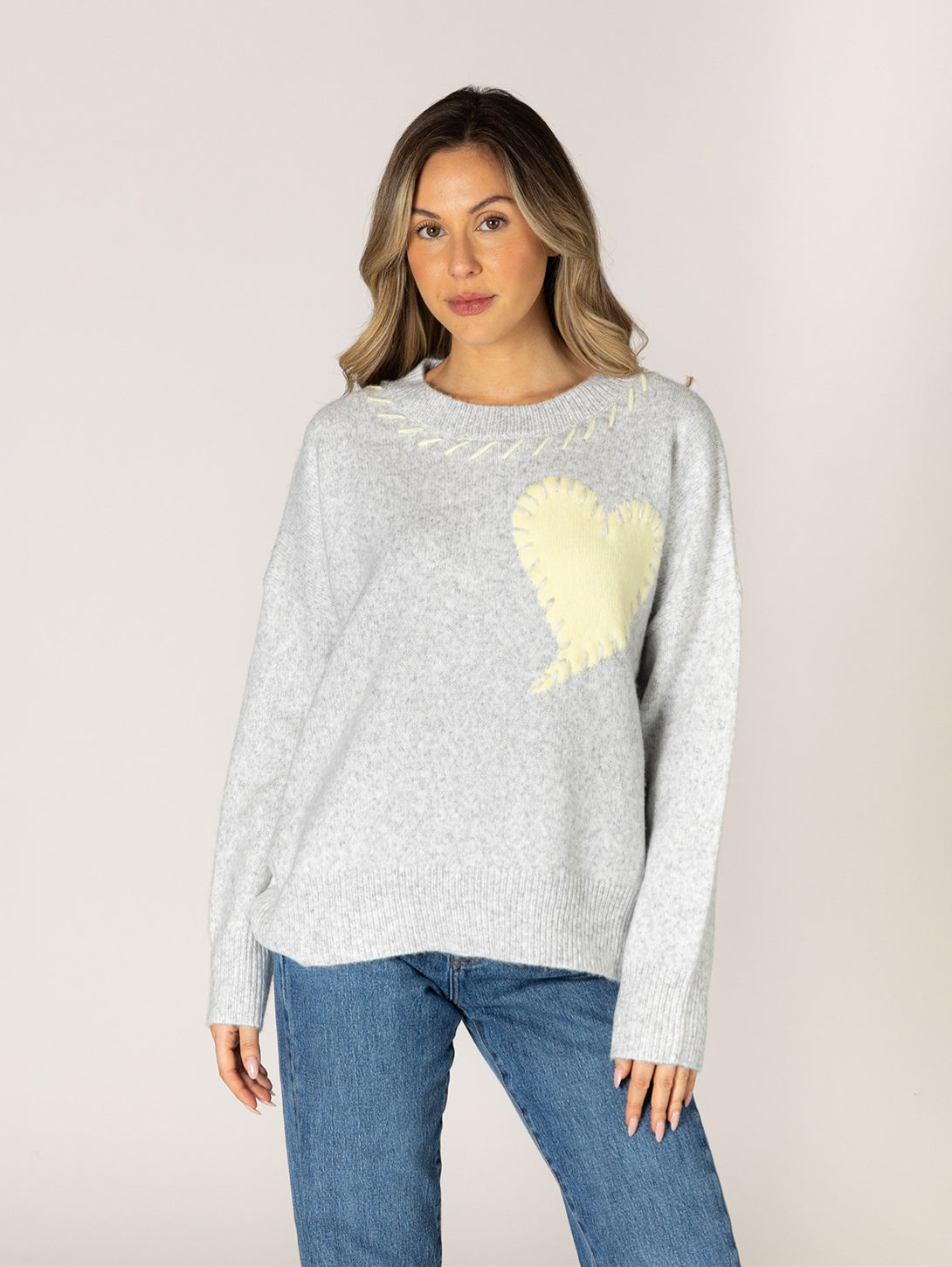 Light grey crew neck sweater with cream heart motif and yellow stitch neckline detail