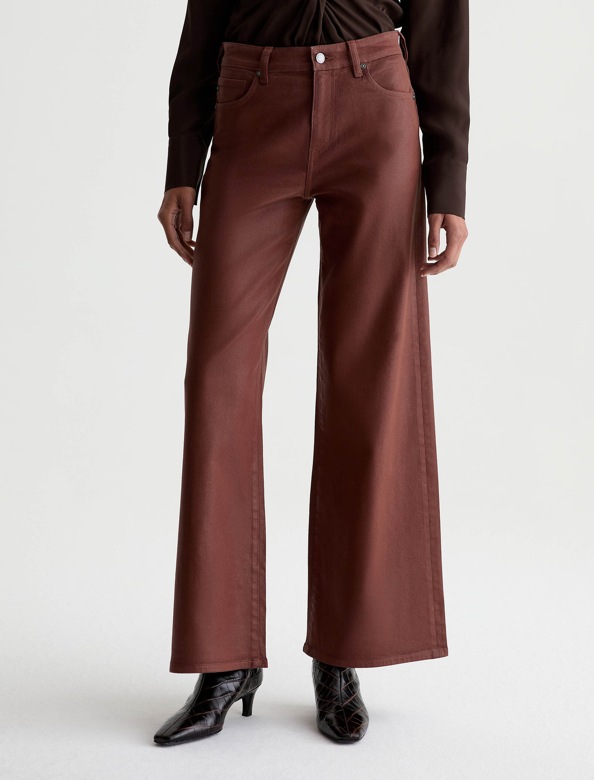 AG Saige Wide Leg pants in light chestnut coated denim, worn by model with black boots