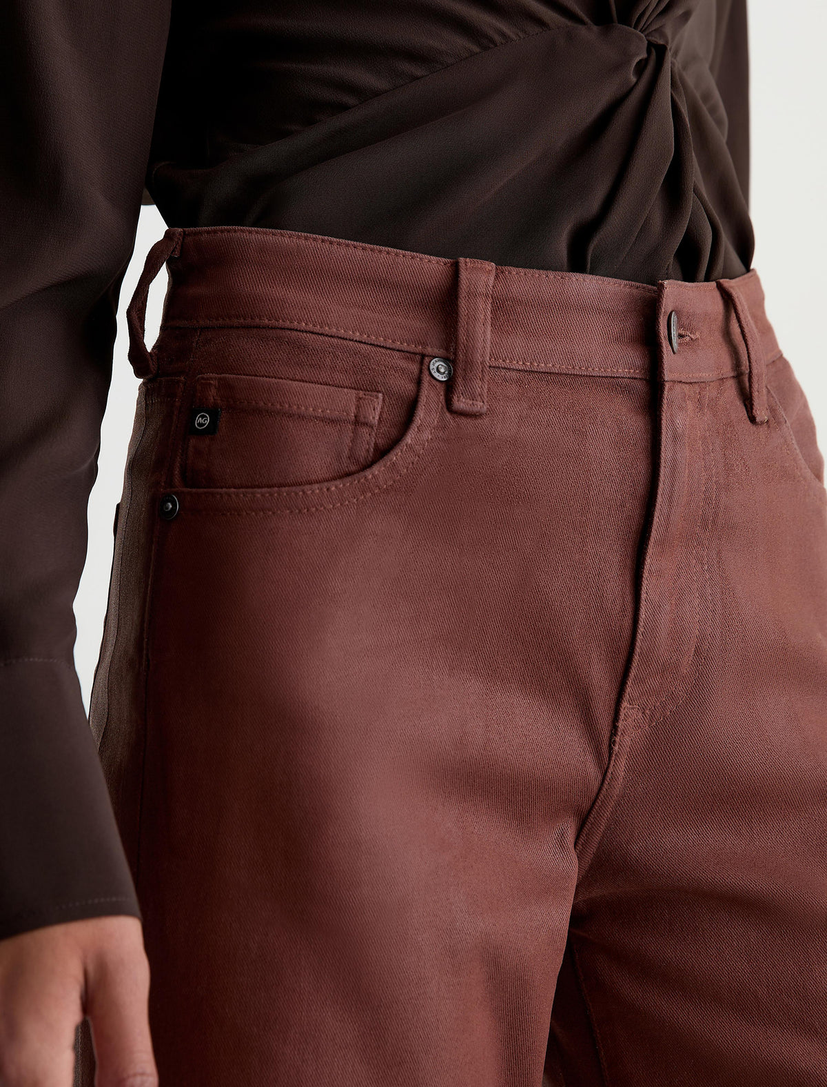 Close-up detail of AG Saige Wide Leg jeans in light chestnut coated fabric with pocket stitching
