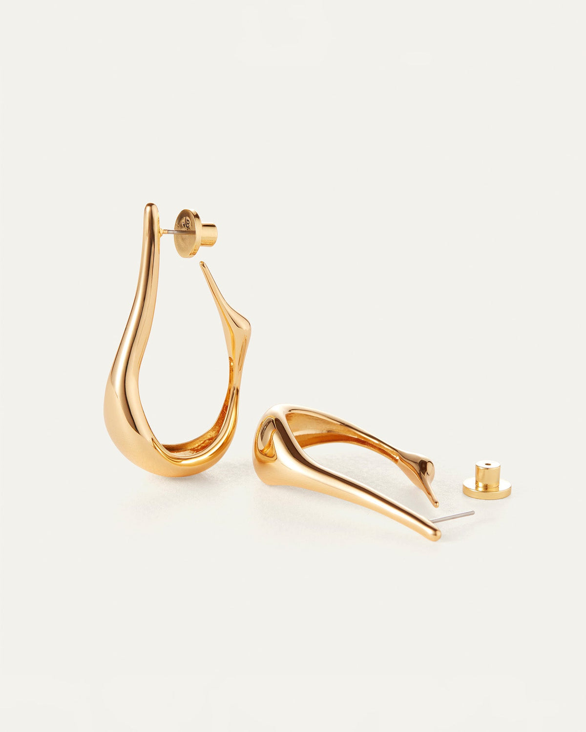 Jenny Bird Egret Hoops in gold tone, shown as a pair with post backings visible