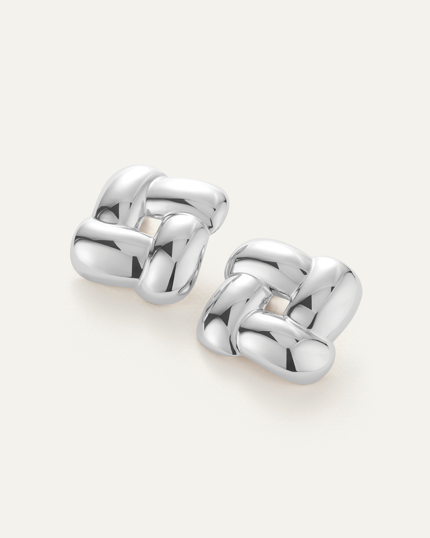 Jenny Bird Gio Earrings in polished silver knot stud design, pair shown on neutral background