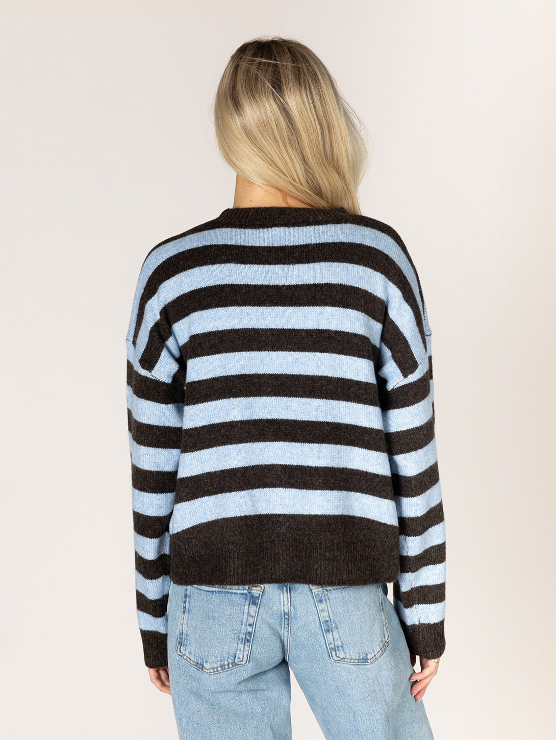 Back view of Heart Stripe Sweater in Ganache and Sky blue horizontal stripes paired with light wash jeans