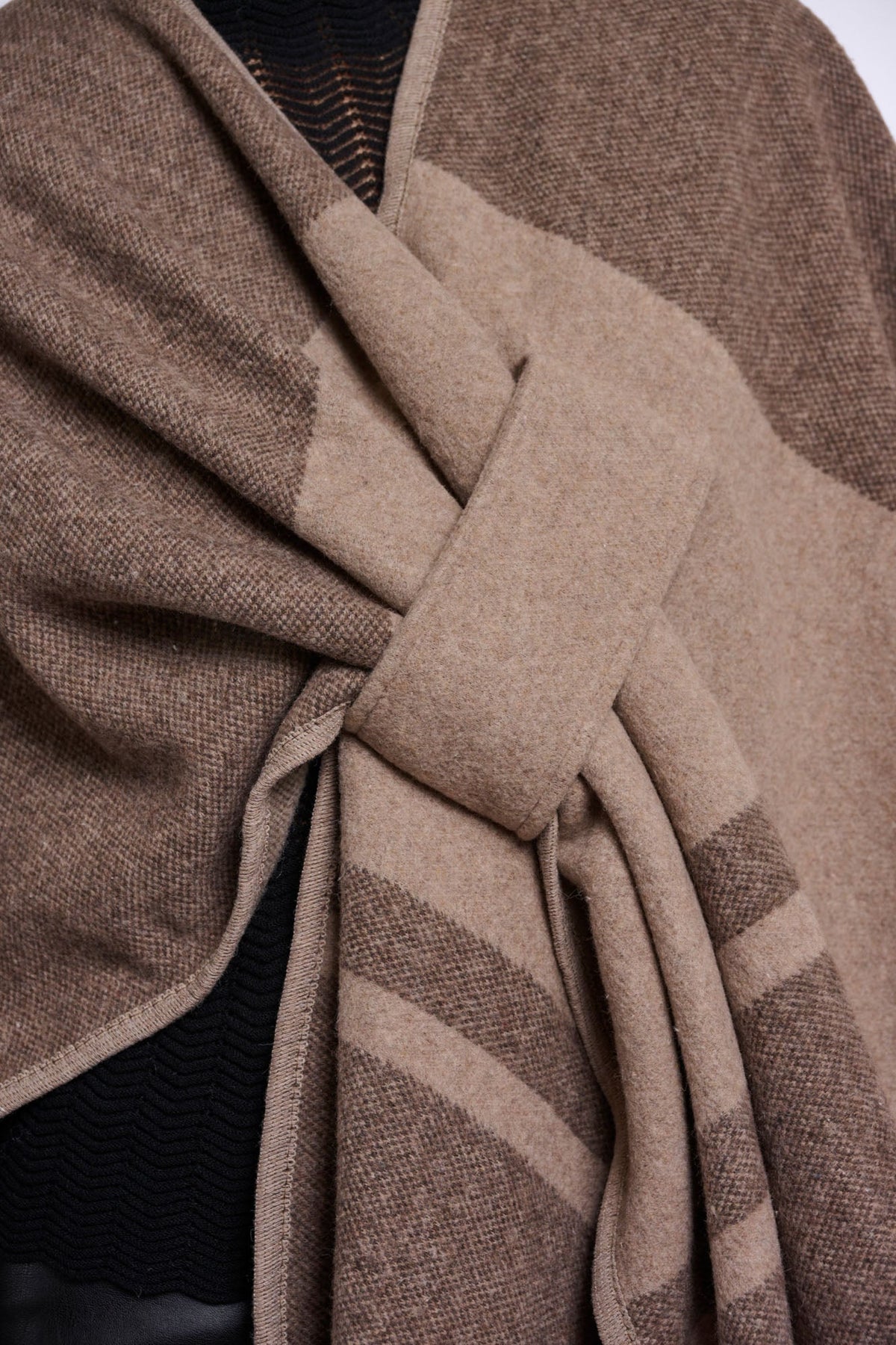 Close-up detail of LEVI wrap scarf in toffee check pattern showing knot and texture