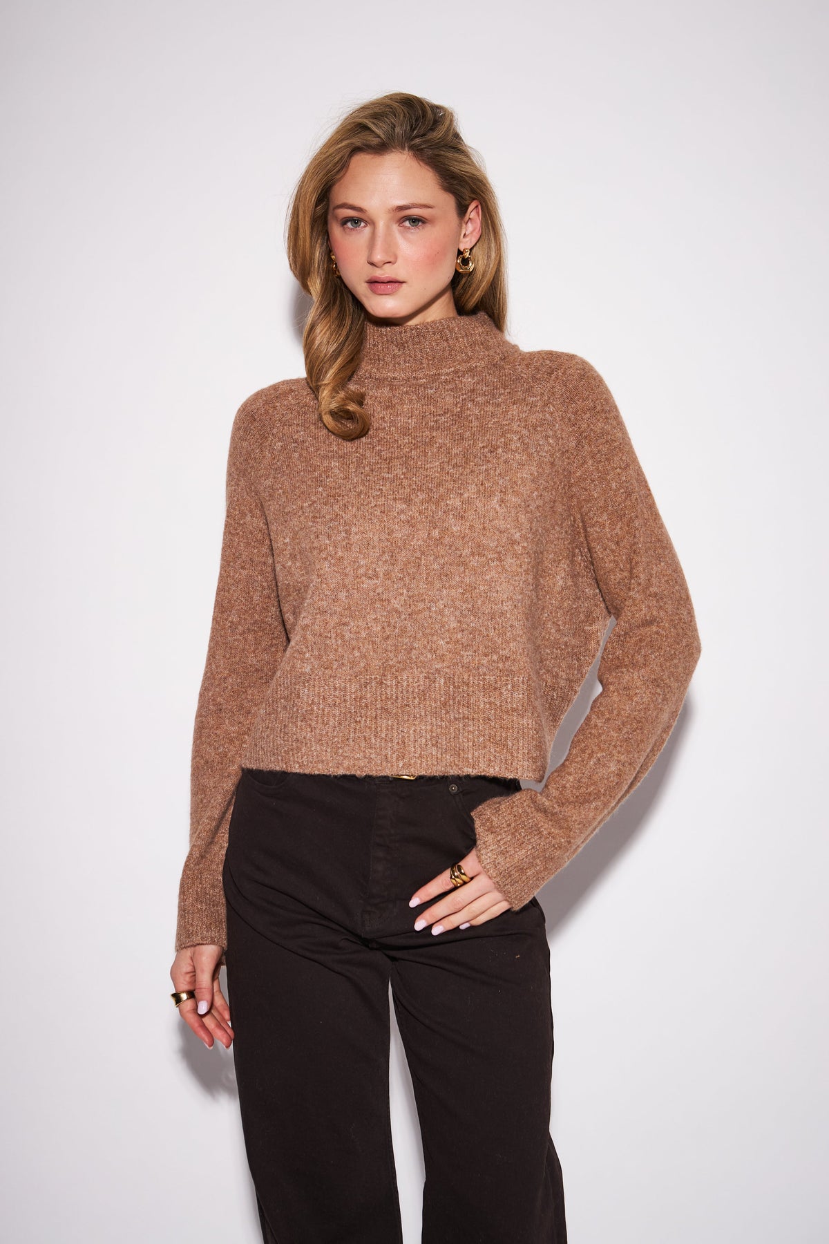 Woman wearing John & Jenn Oliver camel turtleneck sweater with black wide-leg pants
