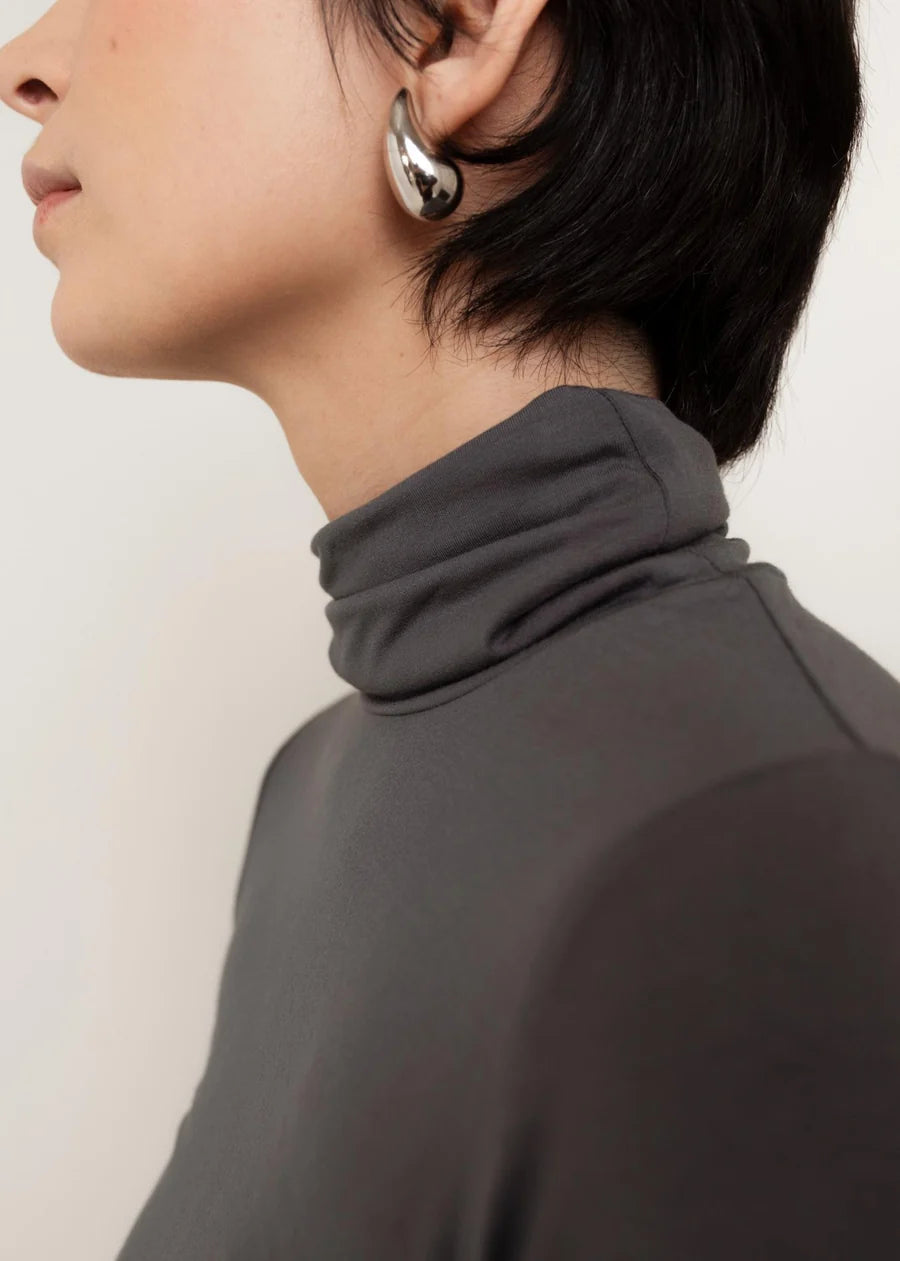 Dark charcoal grey turtleneck top with soft draped cowl neck collar detail