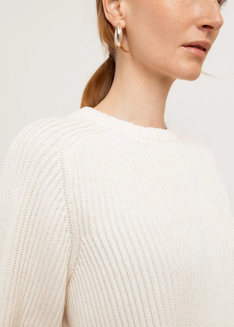White ribbed knit crew neck sweater close-up detail on female model