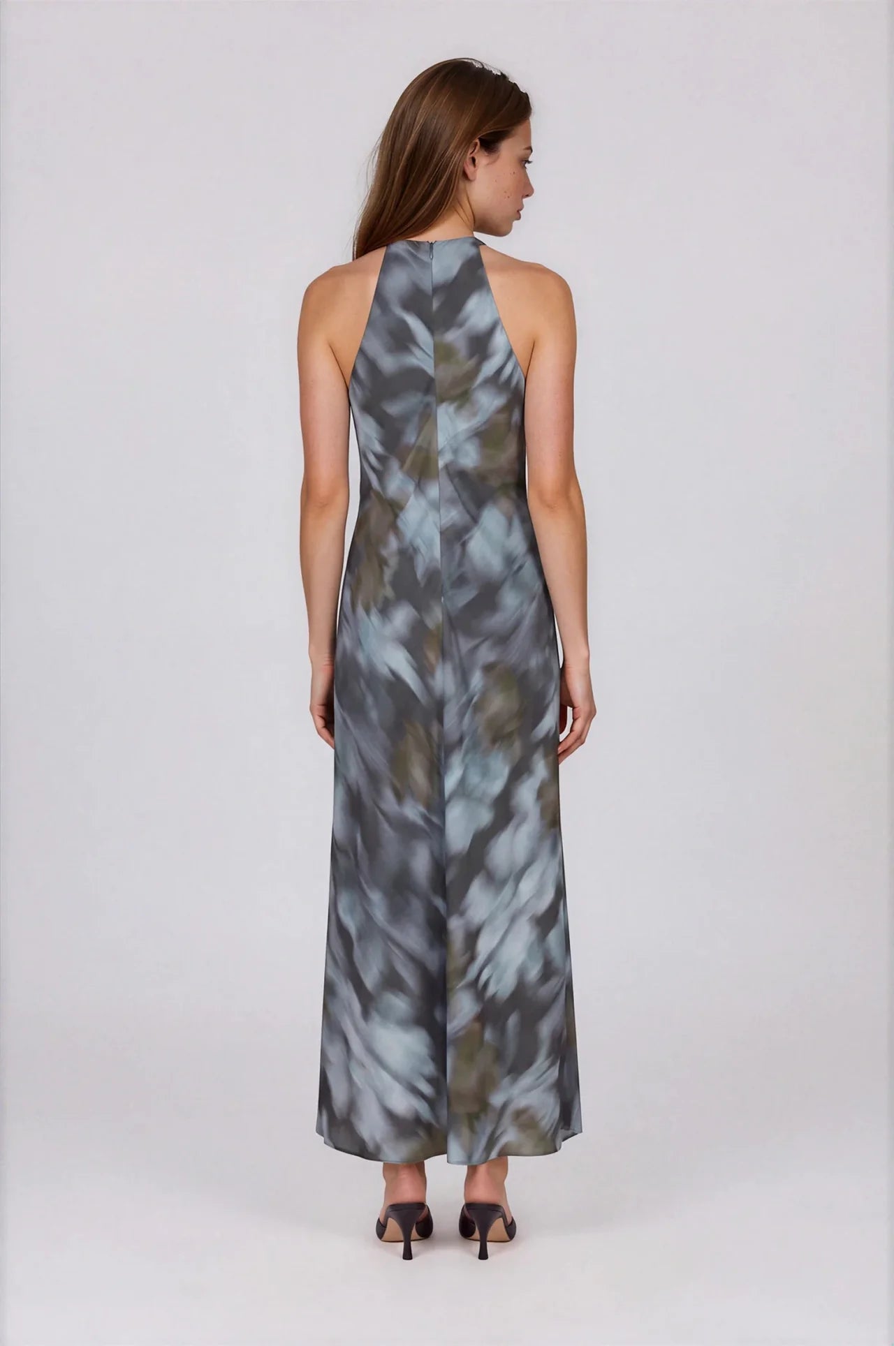 Sleeveless maxi dress in blue-grey abstract floral print with halter neckline, back view