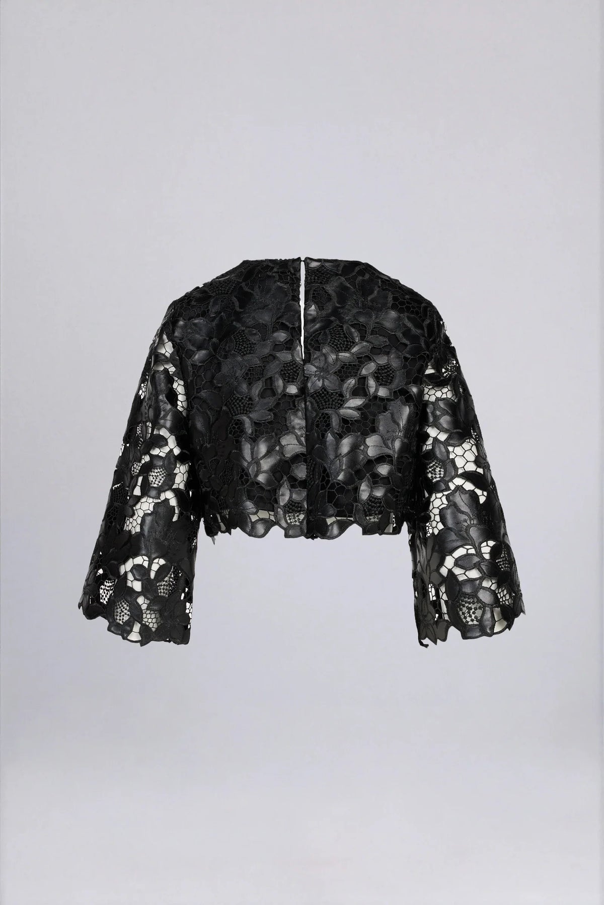 Back view of black floral lace bell sleeve cropped top with back zip closure