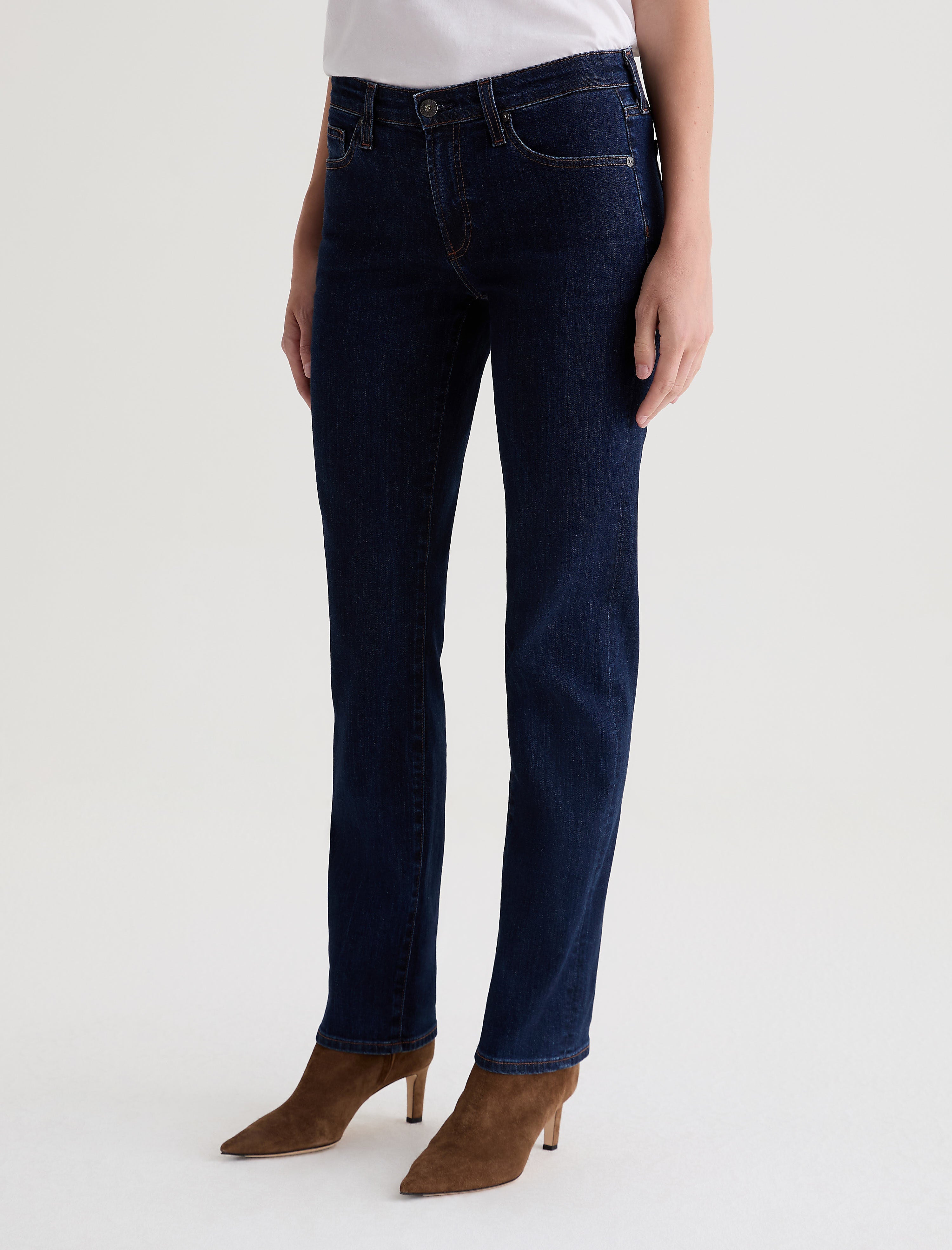 AG Sandra straight-leg jeans in deep modern indigo wash, styled with tan suede boots.