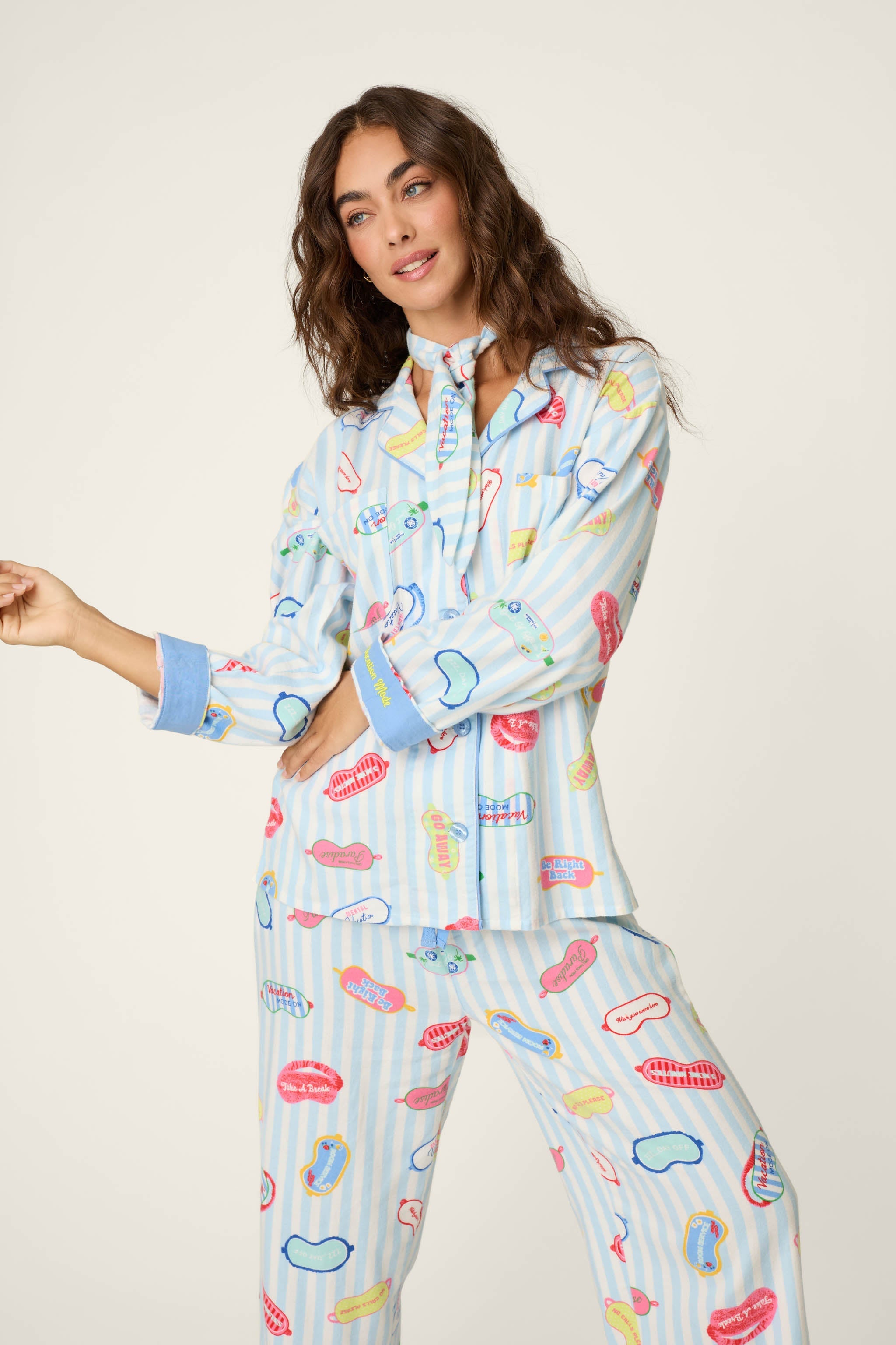 Model wearing PJ Salvage Heritage Set pajamas in light blue stripe with colorful sleep mask print