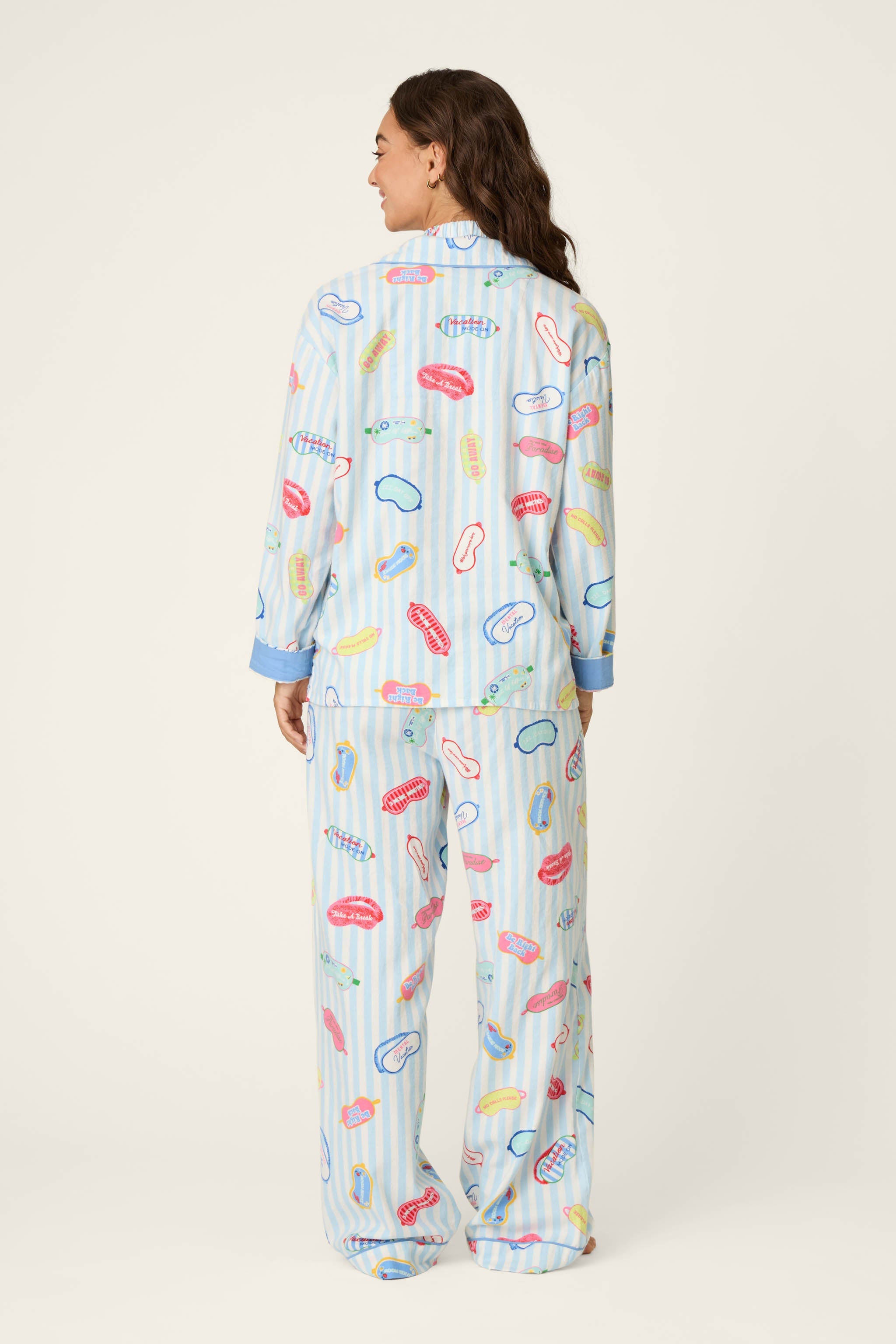 Back view of model wearing PJ Salvage Heritage Set pajamas in light blue stripe with sleep-themed novelty print