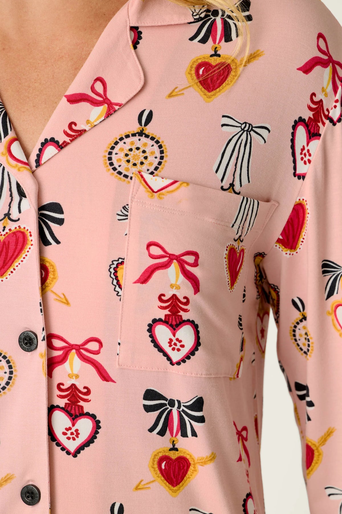 Pink button-up night shirt with hearts, bows, and ornament print, chest pocket