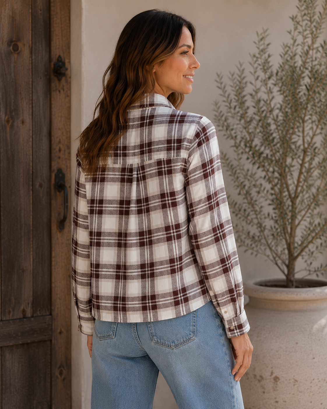 Back view of woman wearing Rails Malin plaid flannel shirt in cream and brown birch hickory colorway with jeans.