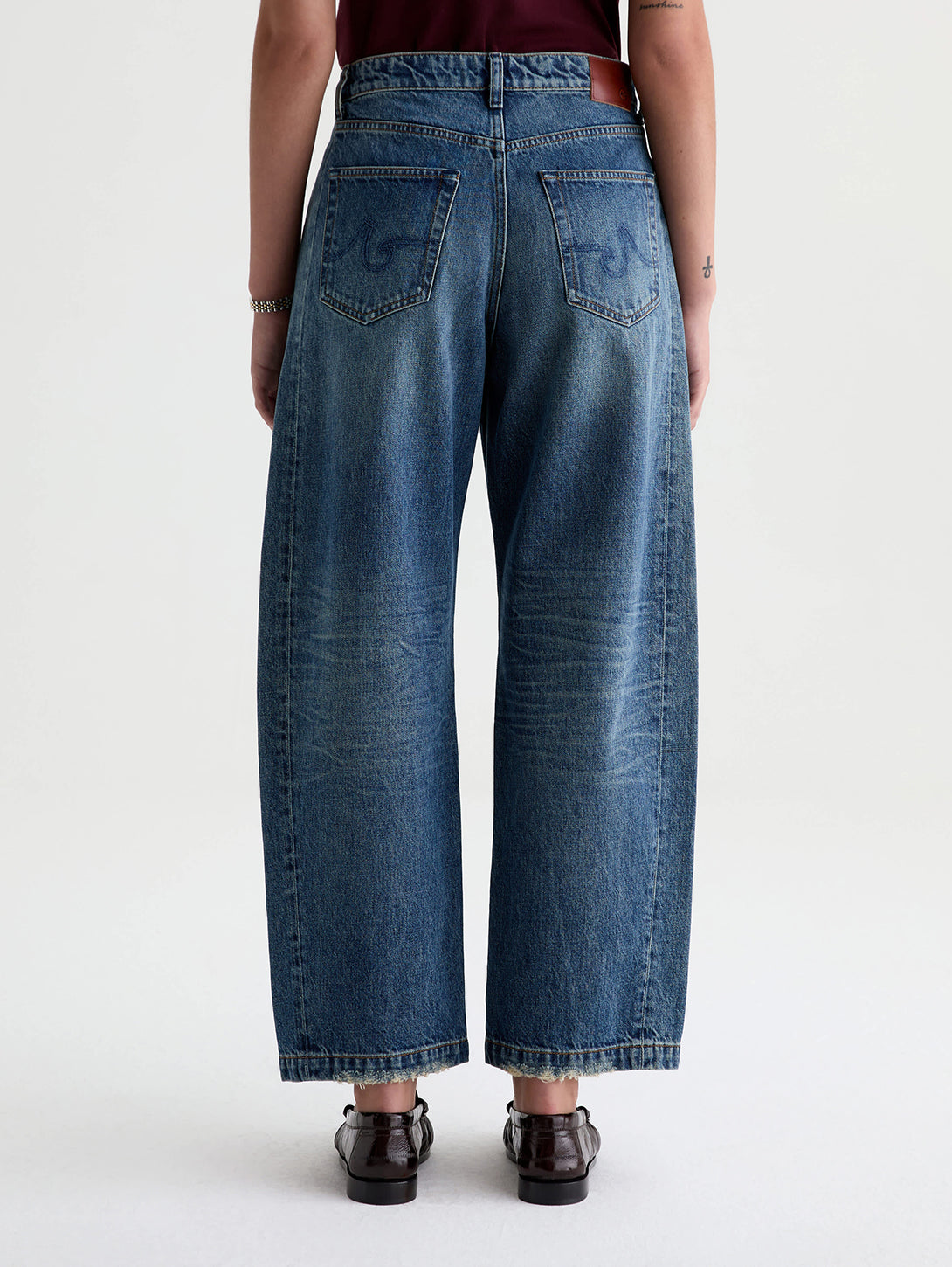 Back view of AG Hattie wide-leg barrel jeans in medium vintage blue wash on model