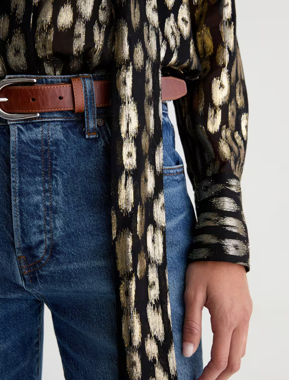 AG Lora dark wash blue jeans styled with brown leather belt and gold leopard blouse