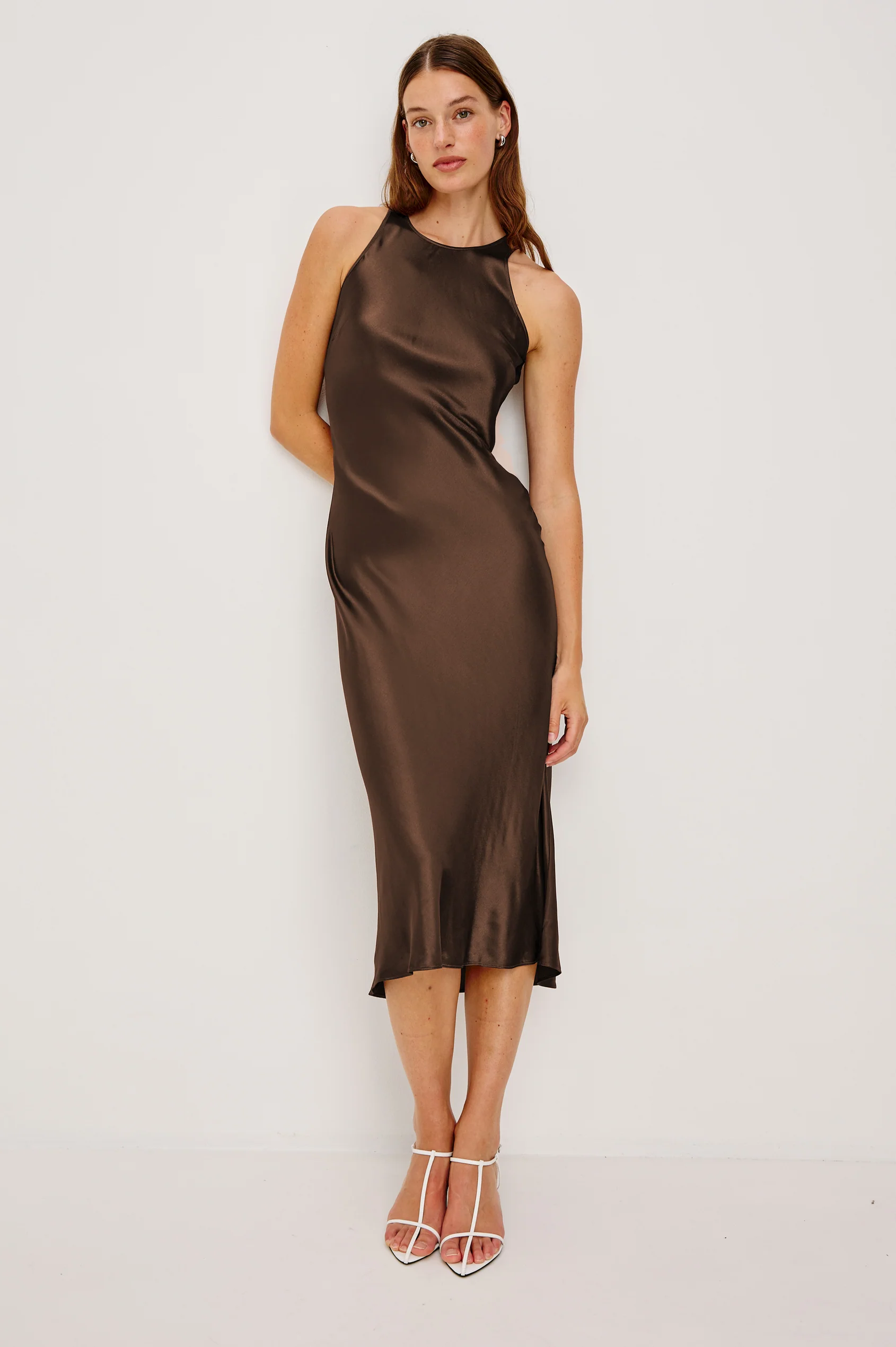 Model wearing Rails Solene Espresso satin midi dress with halter neckline and white heels