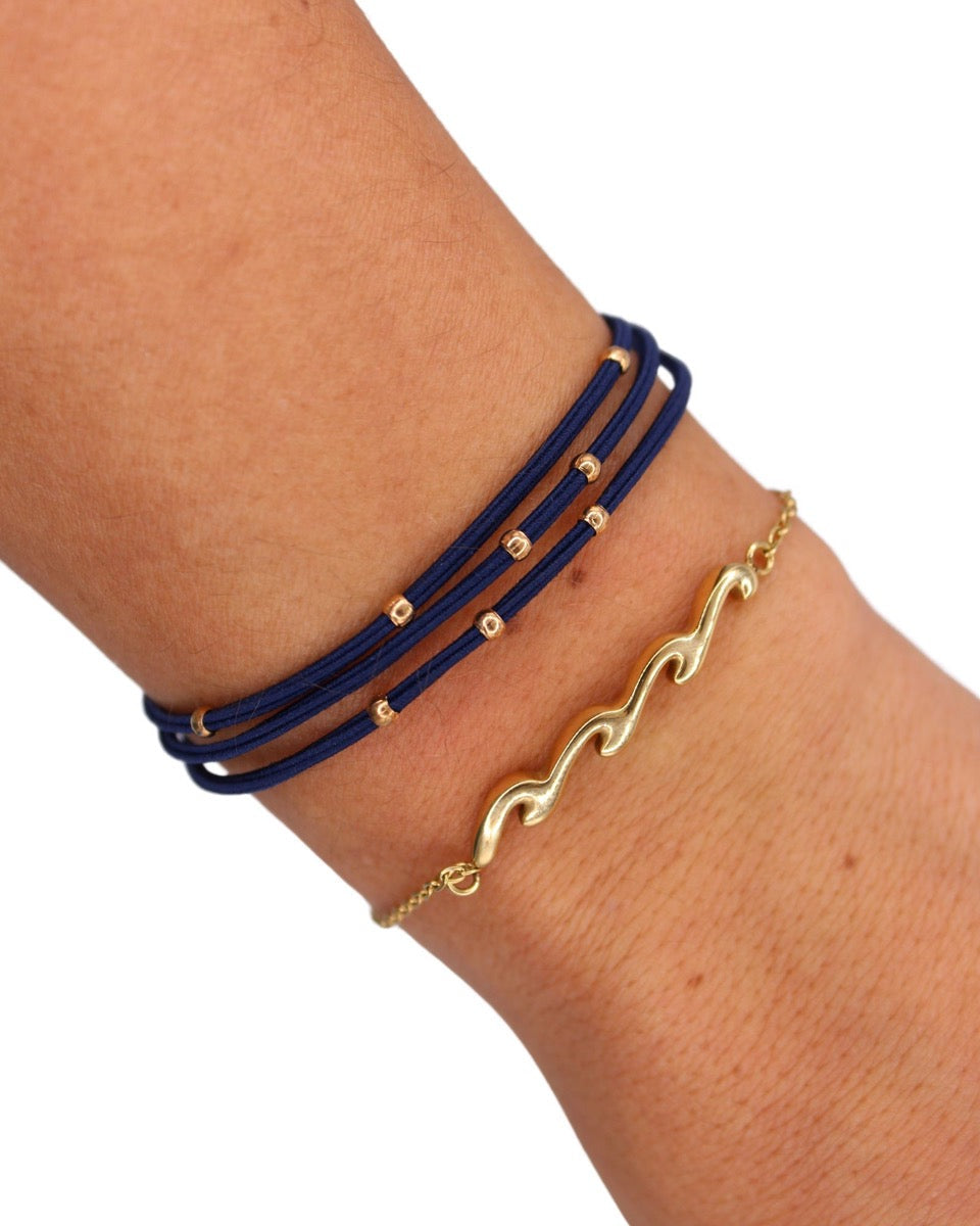 Gypsea Bands hairtie wave charm set in navy blue and gold worn on wrist