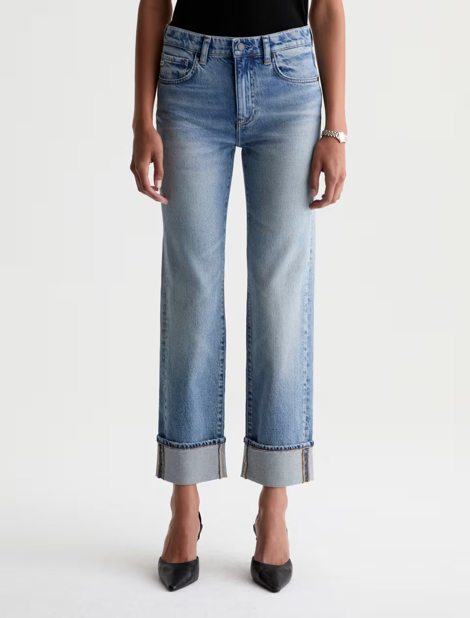 AG Brinley light wash straight-leg jeans with wide cuffed hem, worn with black heels