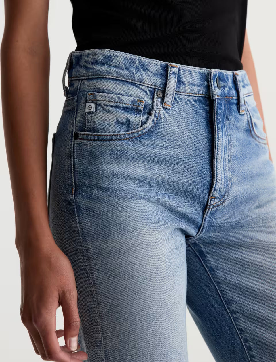 AG Brinley light wash blue denim jeans close-up showing waist and front pocket