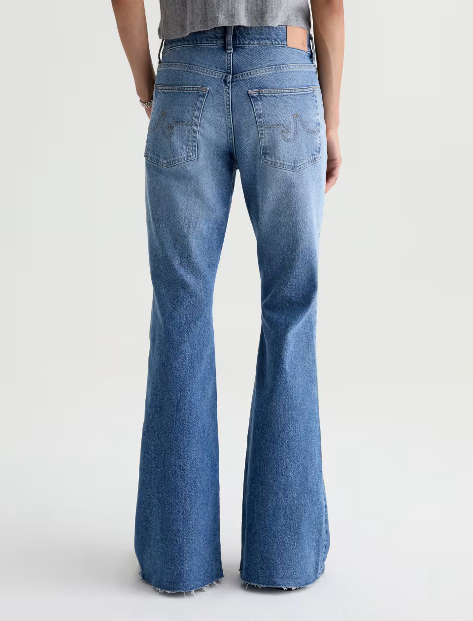 AG Georgia flare jeans in medium blue wash, raw hem, back view
