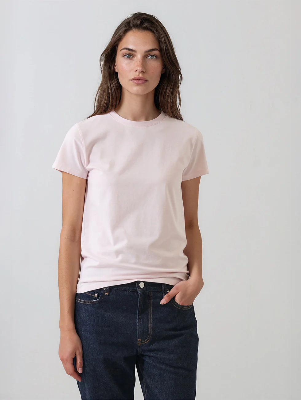 Women's fitted pale pink crew neck short sleeve t-shirt with dark jeans