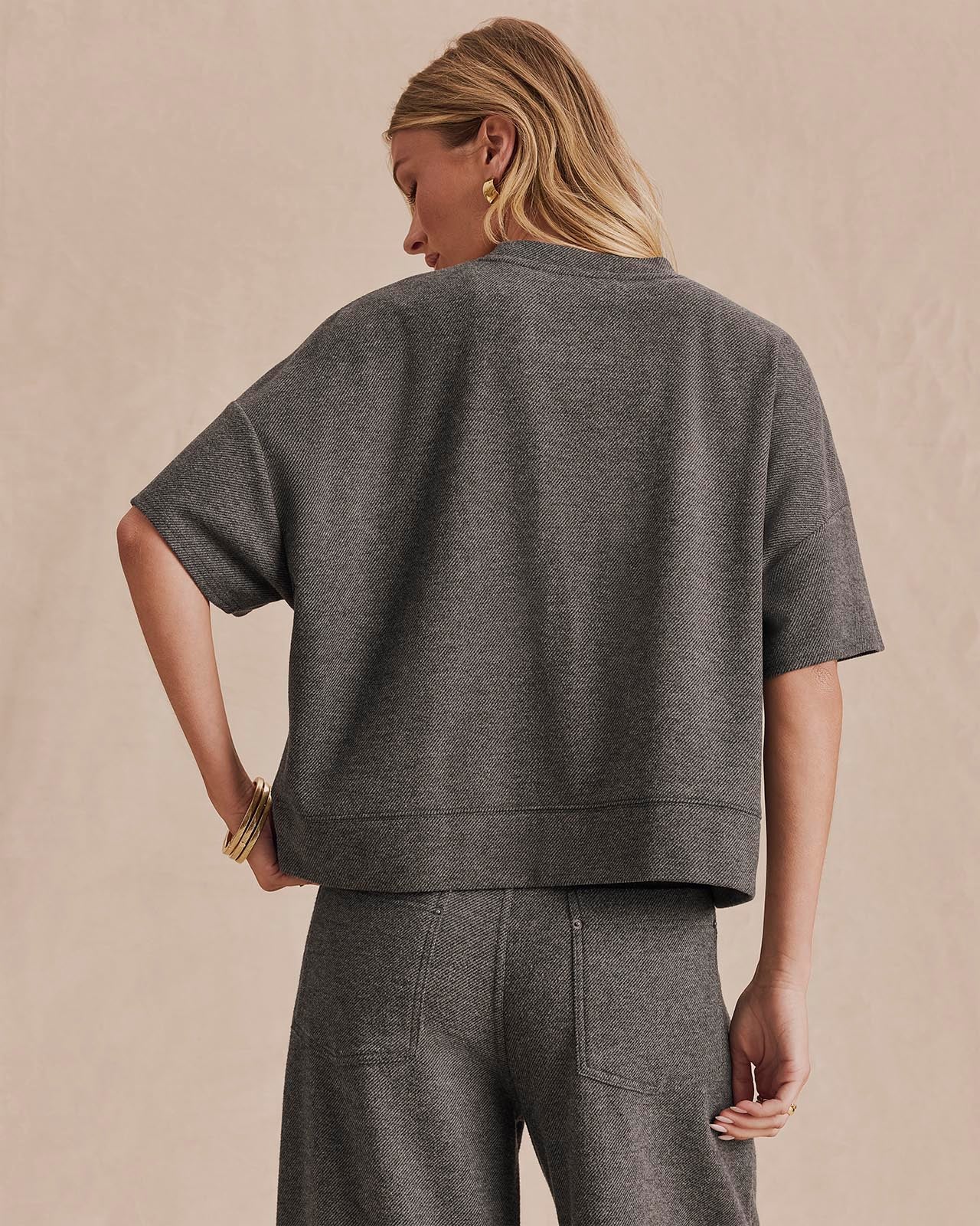 Back view of woman wearing charcoal short-sleeve boxy knit top with matching trousers