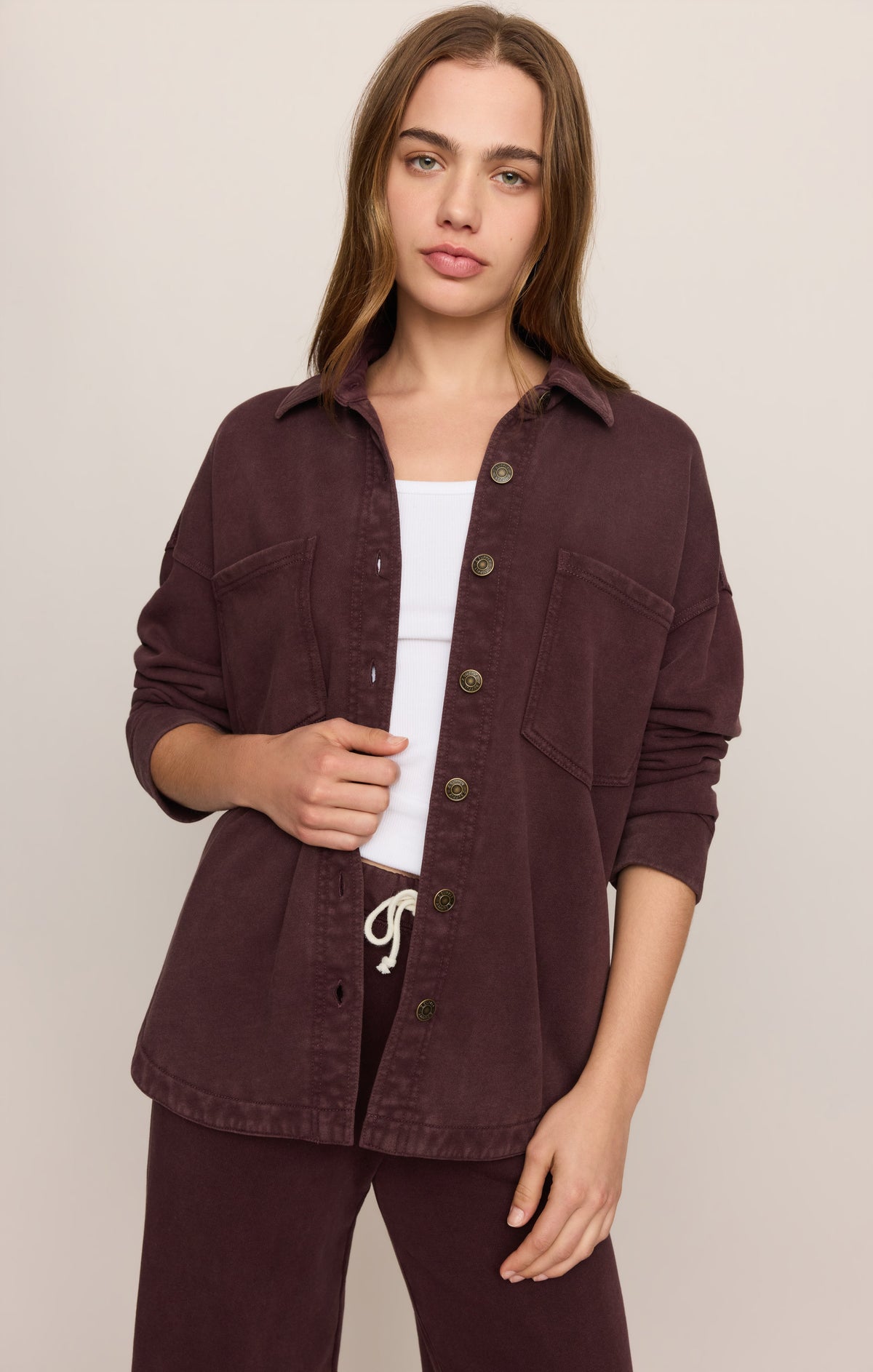 Model wearing Z Supply All Day Knit Jacket in Berry Noir over white tank top with matching pants