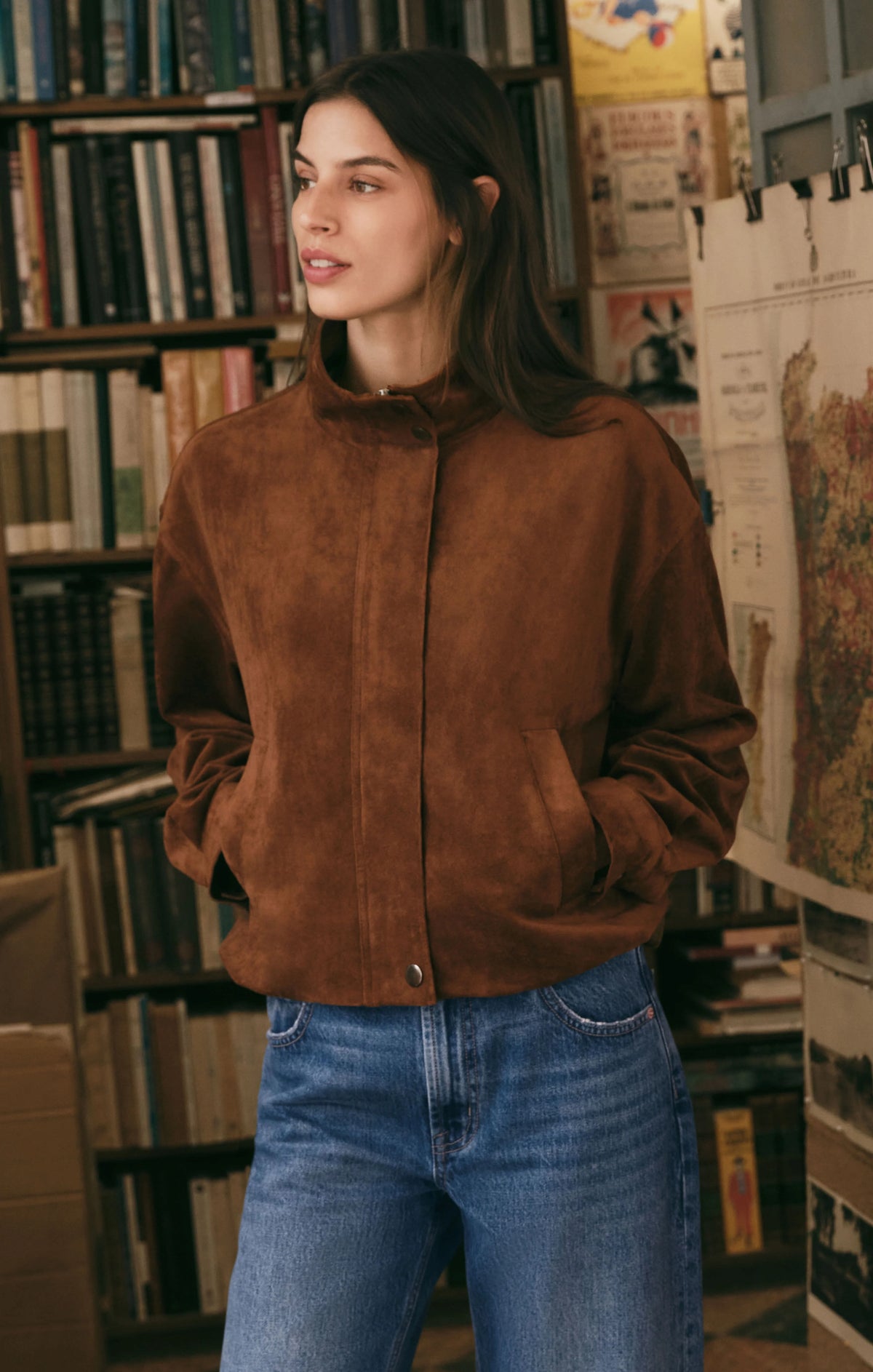 Brown suede bubble hem jacket with mock neck and snap closure worn with jeans