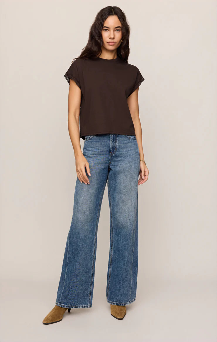 Dark brown muscle tee with lace trim sleeves, worn with wide-leg jeans